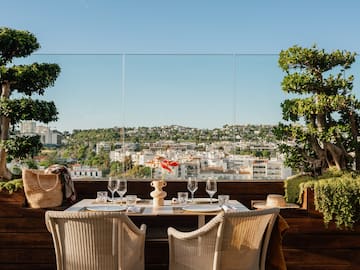 a table with wine glasses and a view of a city