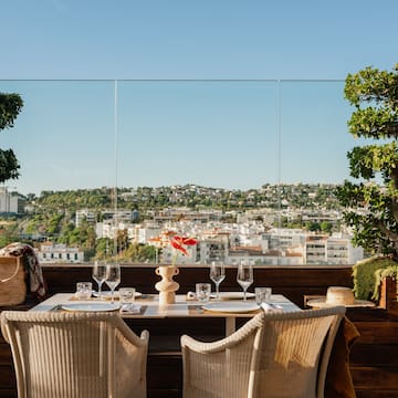 a table with wine glasses and a view of a city