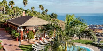 a pool and a gazebo with palm trees and a beach