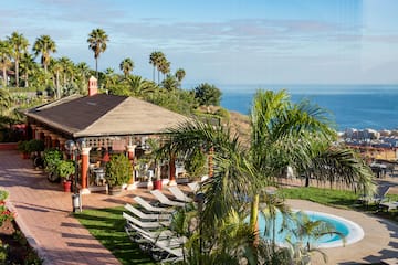 a pool and a gazebo with palm trees and a beach