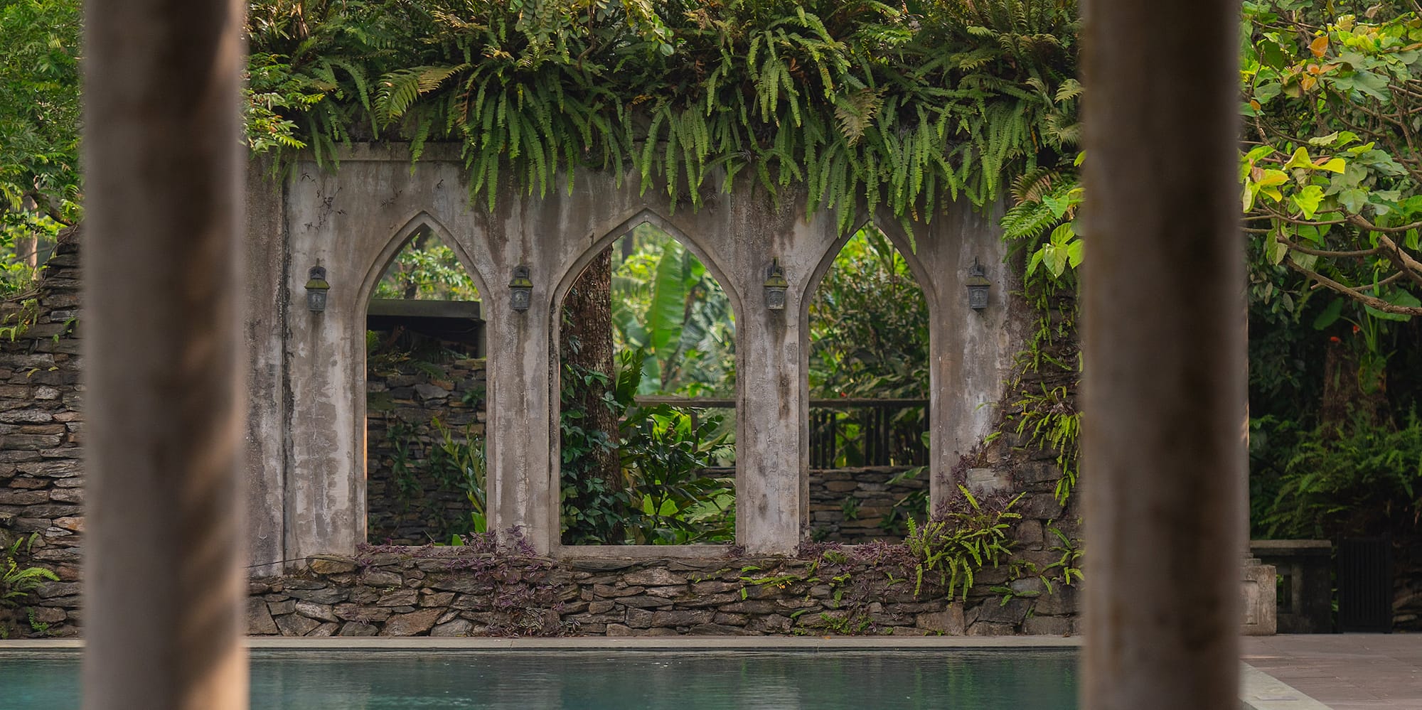 a pool with a stone wall and a stone wall with a stone wall and a stone wall with a stone wall and a stone wall with a stone wall with a stone wall and a stone wall with