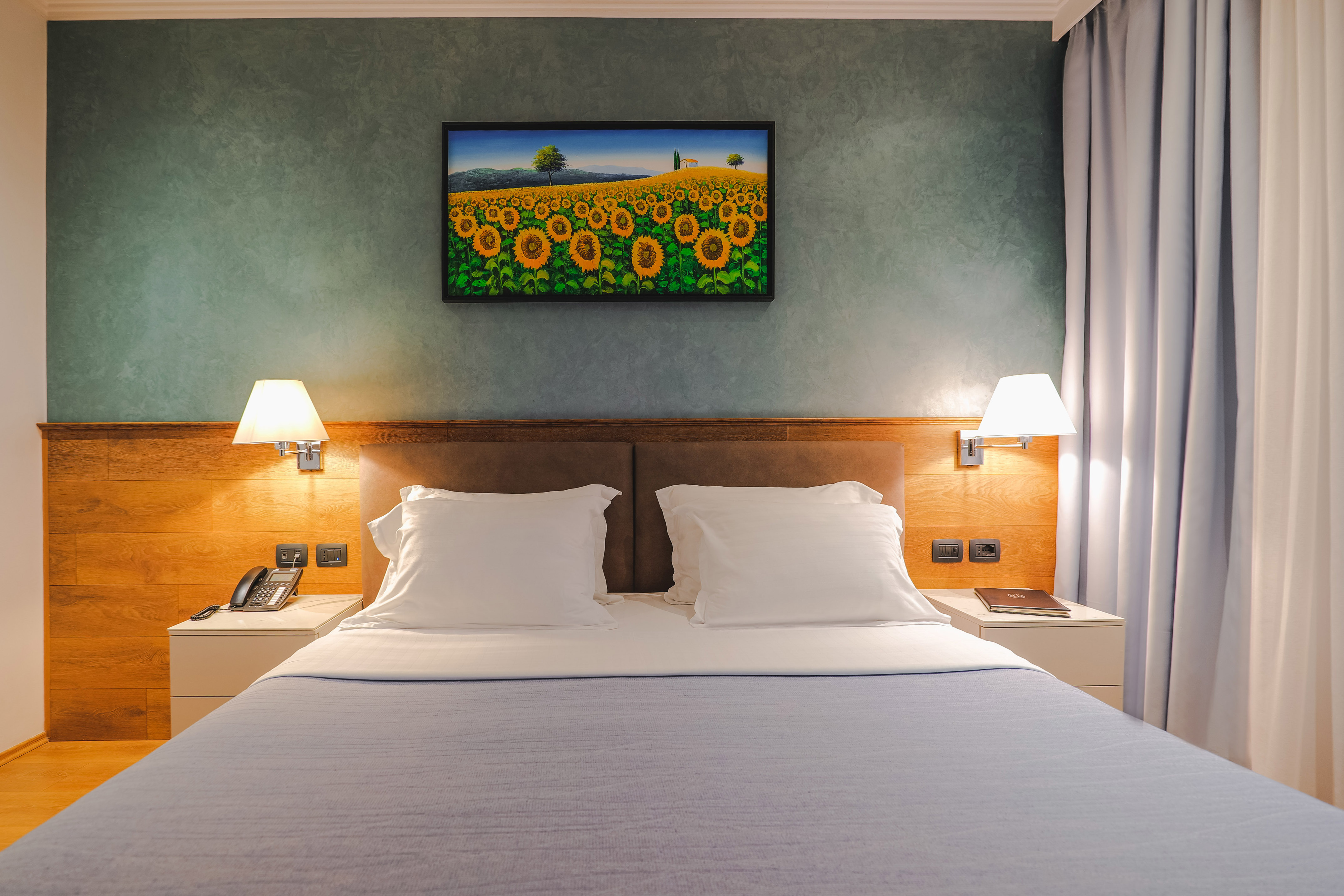 a bed with a picture of sunflowers on the wall