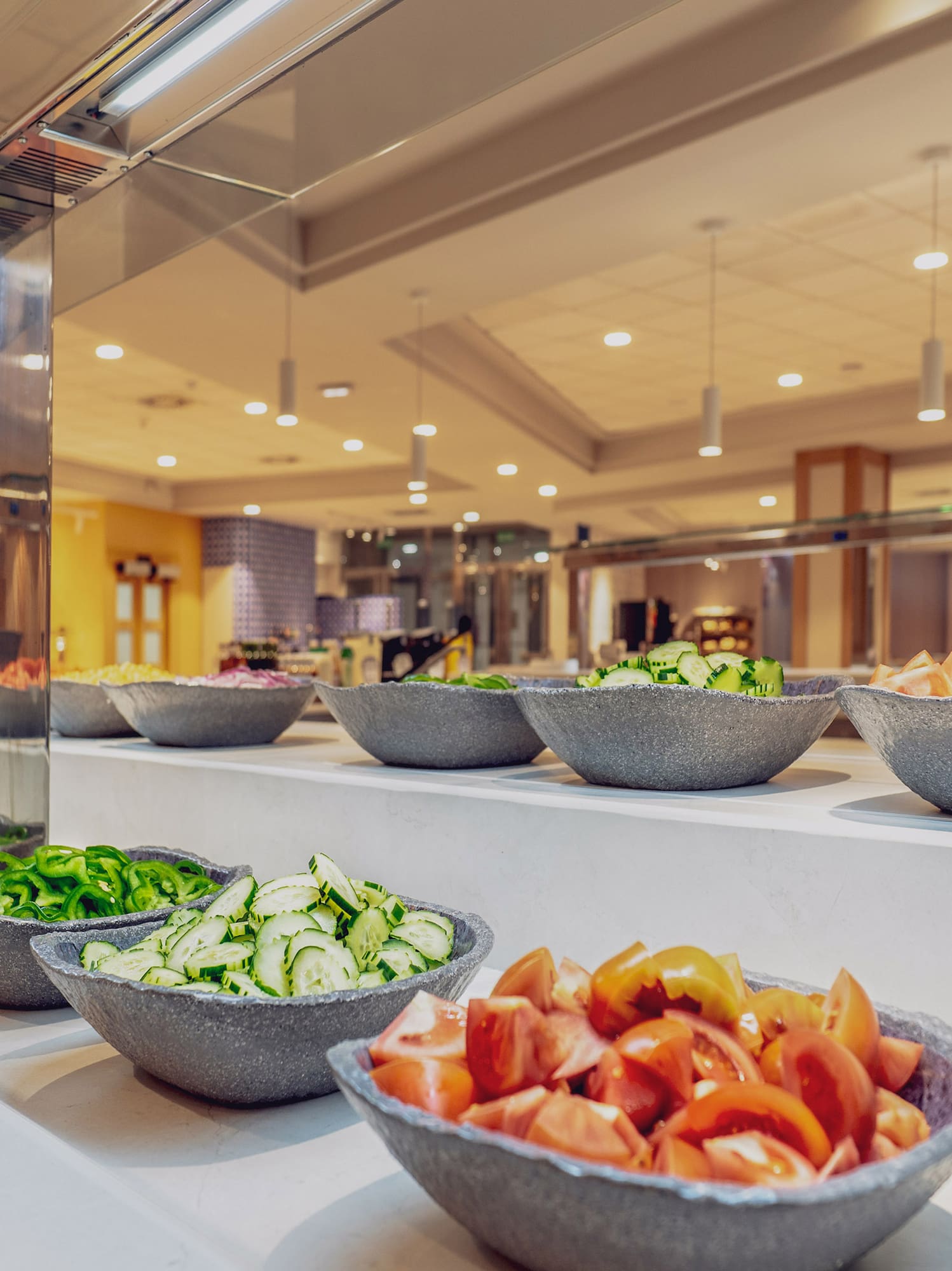 a salad bar with bowls of vegetables