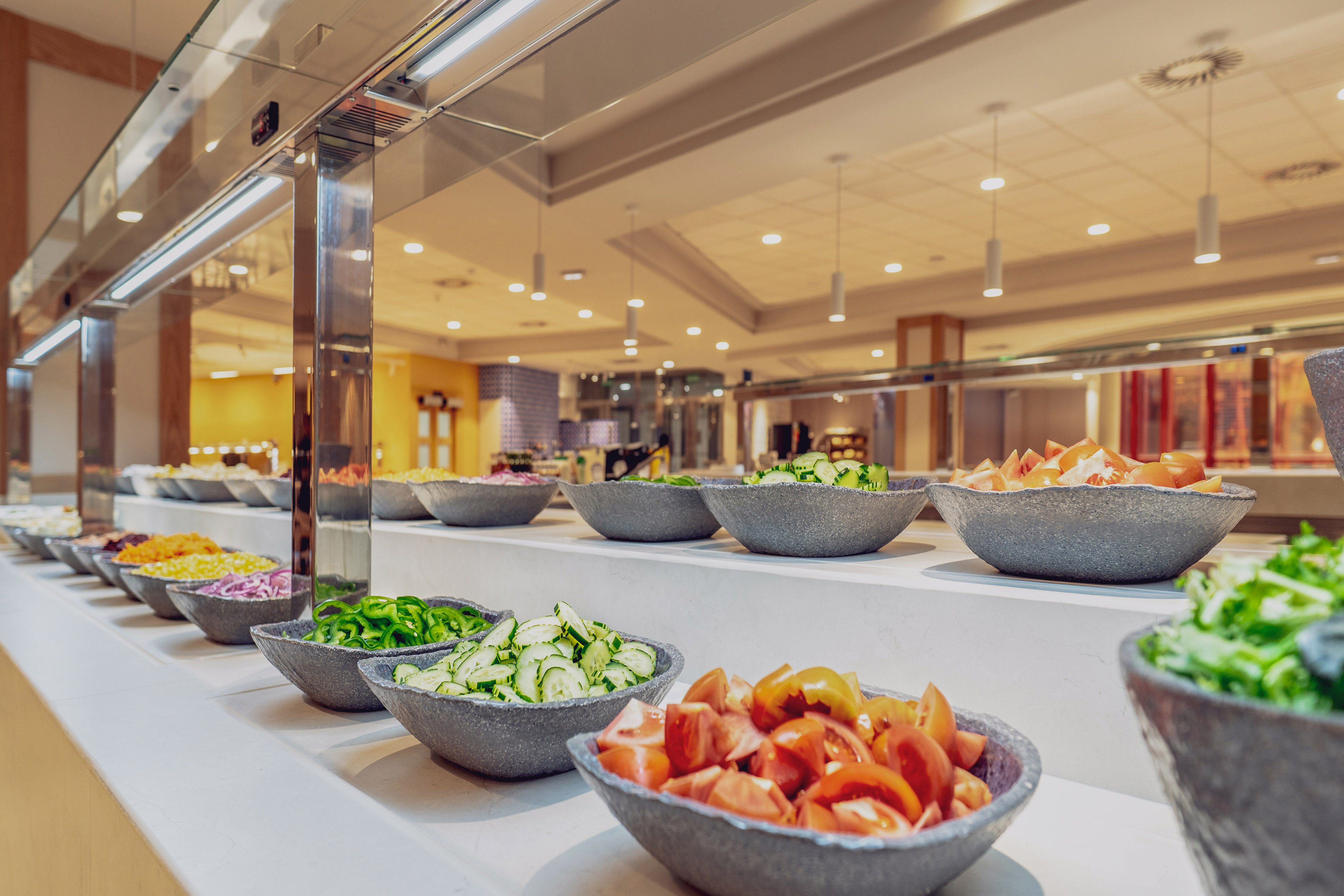 a salad bar with bowls of vegetables