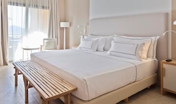 a bed with white sheets and a bench