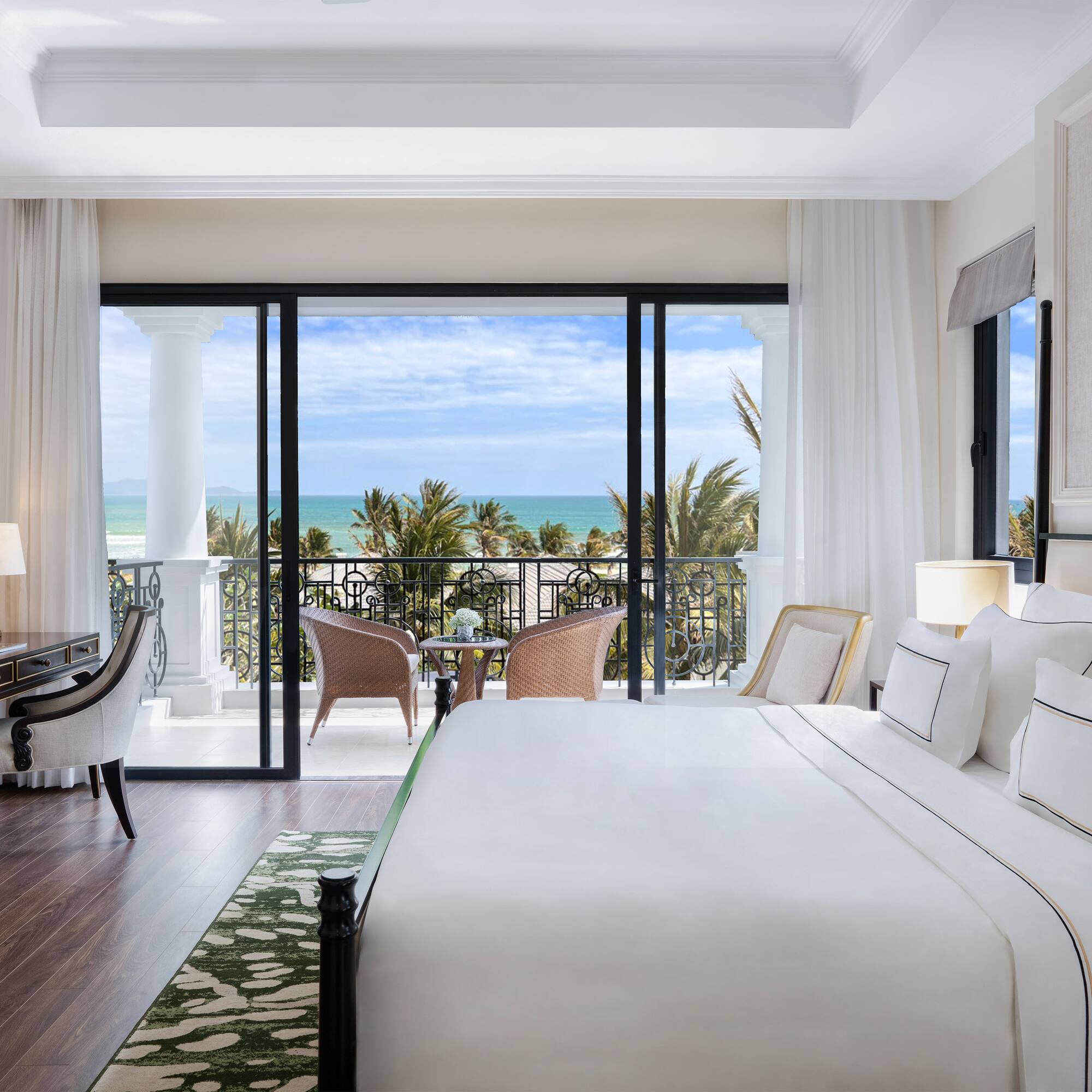 a bedroom with a balcony overlooking the ocean