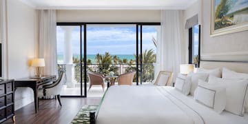 a bedroom with a balcony overlooking the ocean