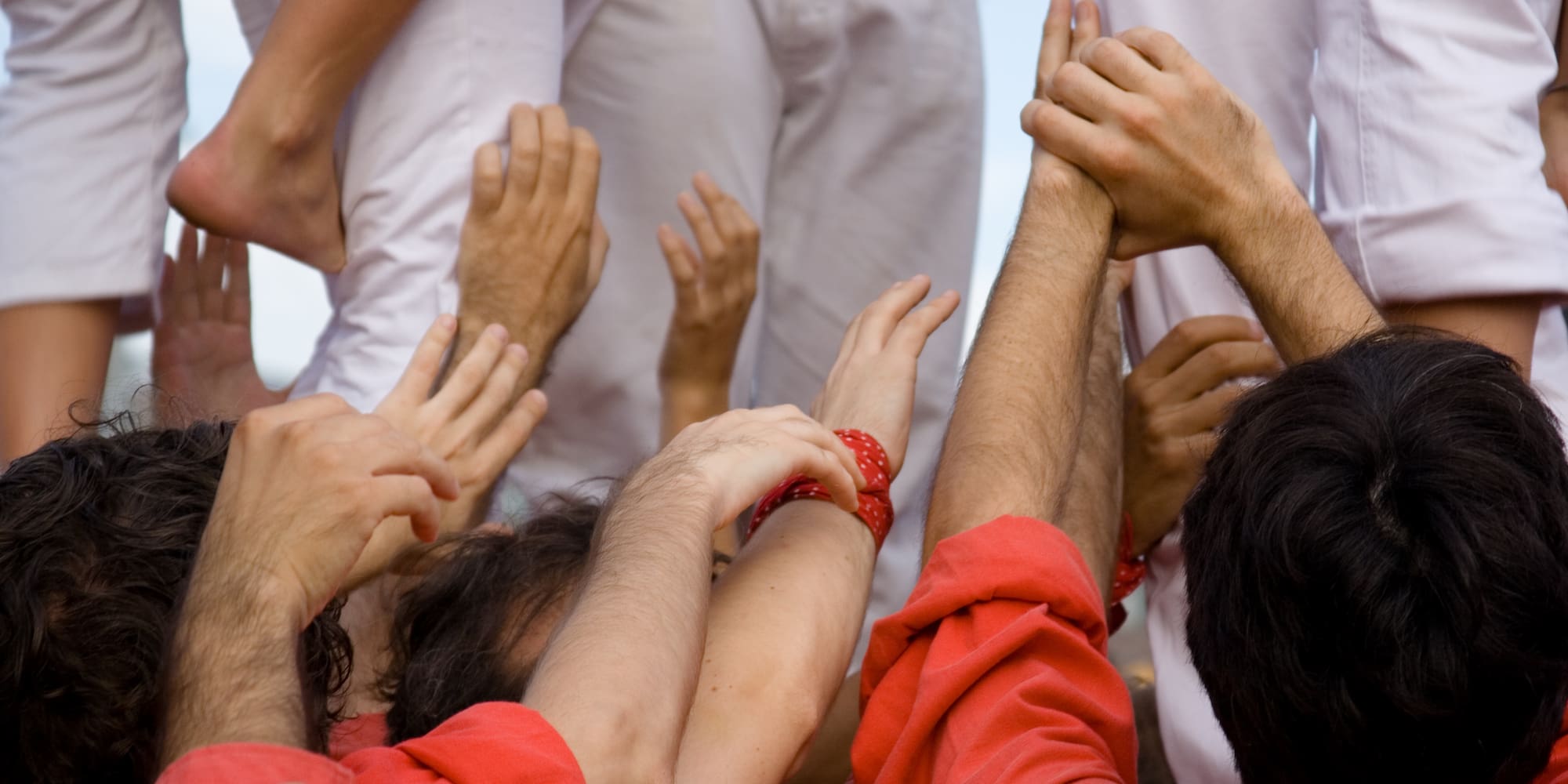 Castellers: manos, brazos y pies formando una torre humana.