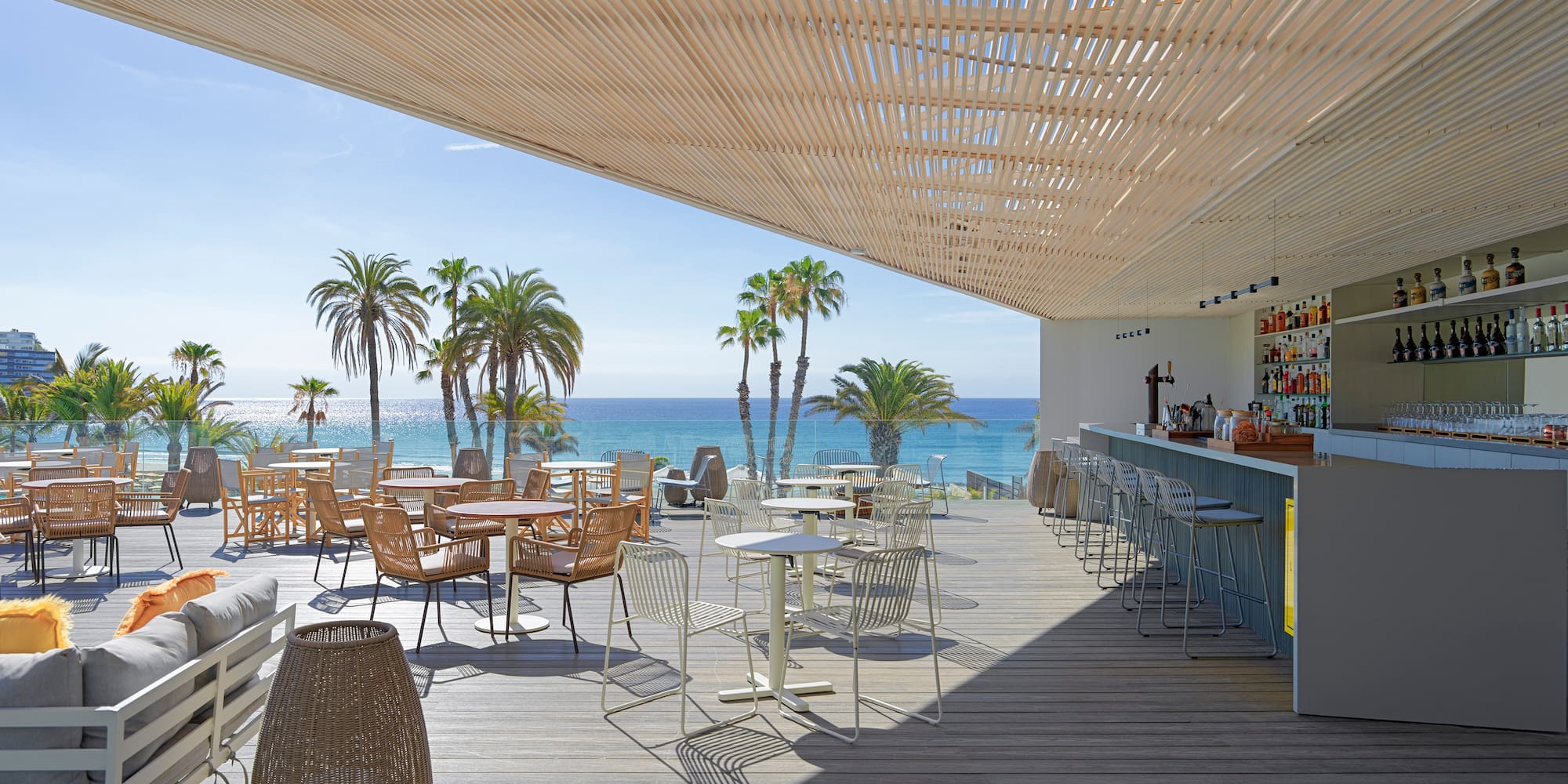 a restaurant with tables and chairs on a deck overlooking the ocean