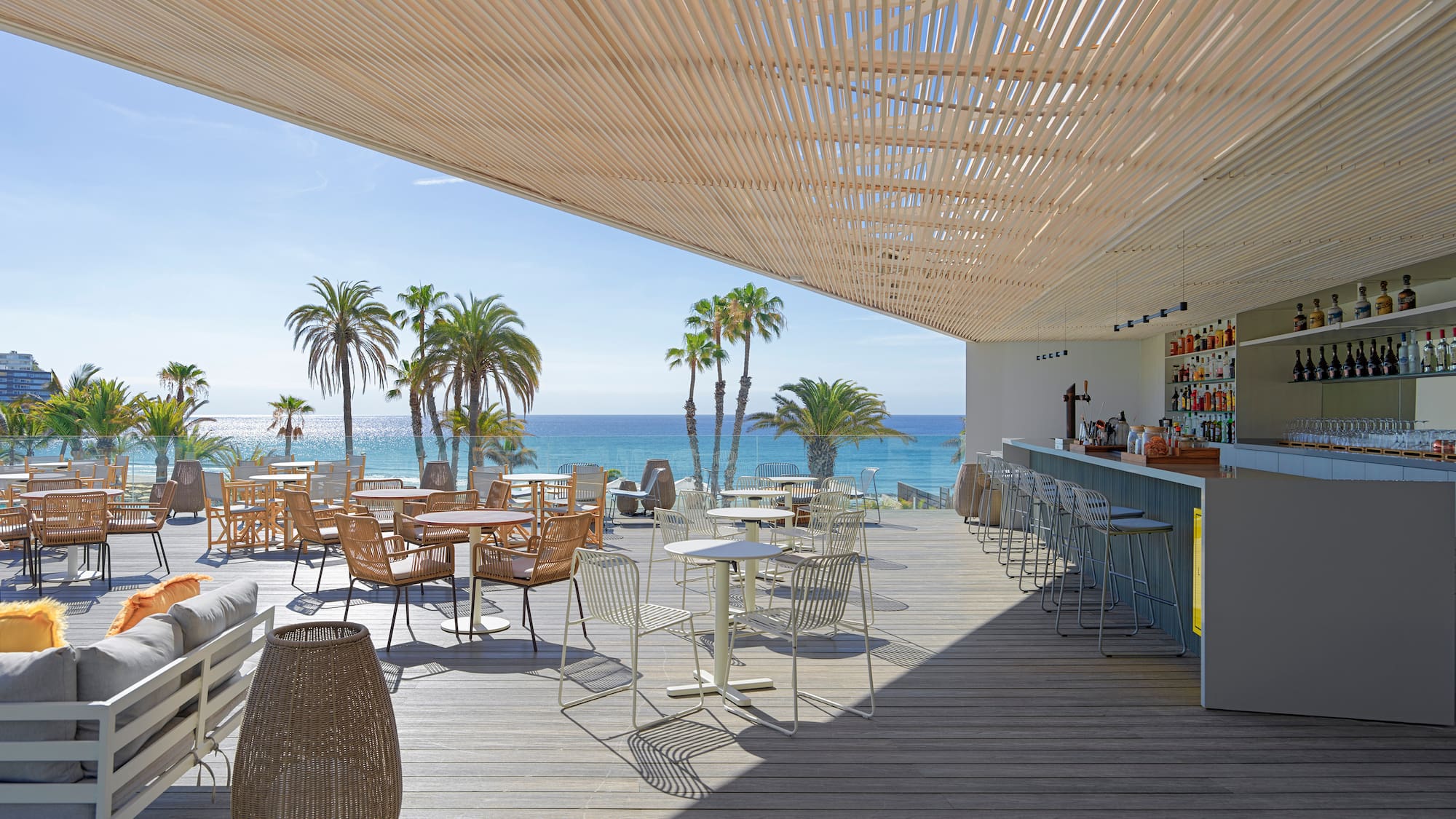 a restaurant with tables and chairs on a deck overlooking the ocean