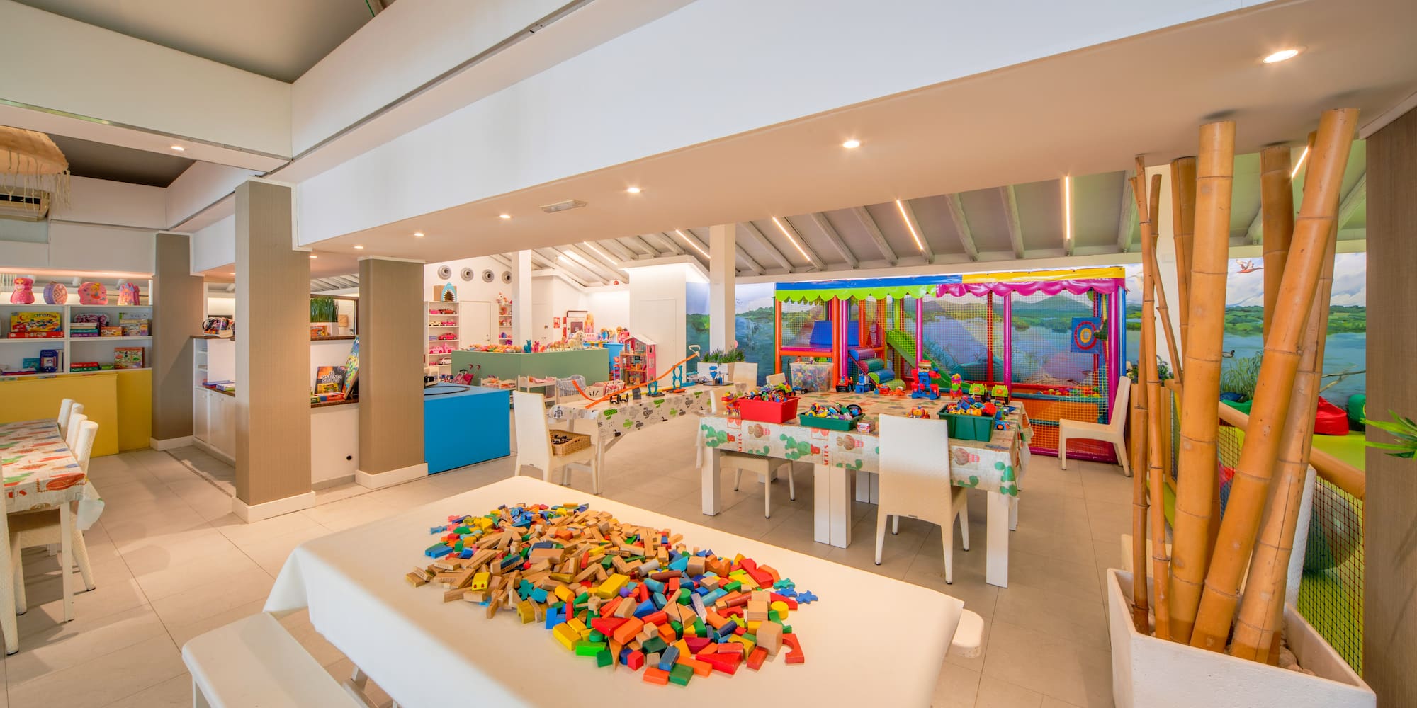 a room with white tables and white chairs and a table with colorful blocks