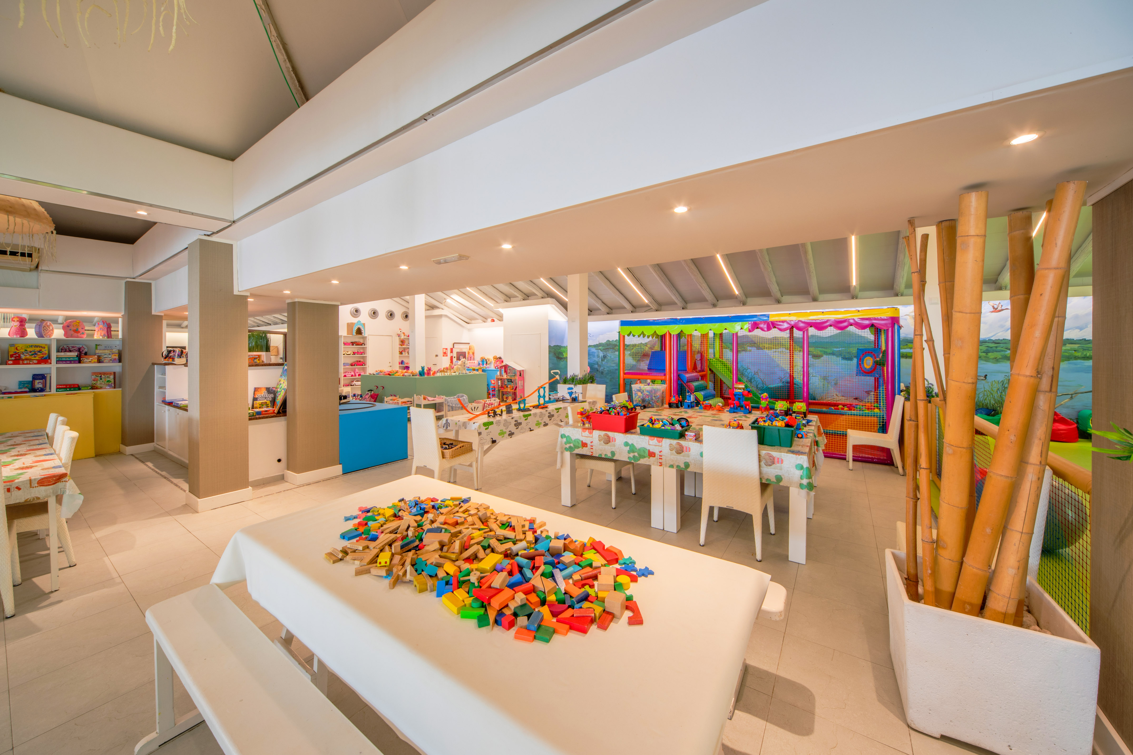 a room with white tables and white chairs and a table with colorful blocks