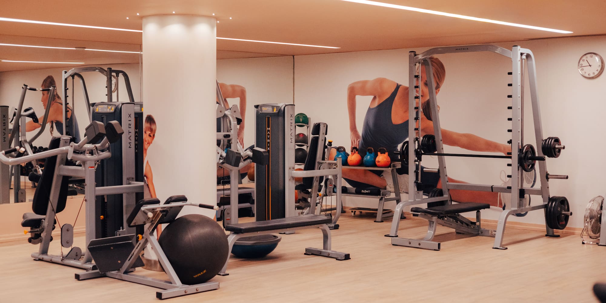Spacious gym with Matrix fitness equipment, kettlebells, and weight machines.