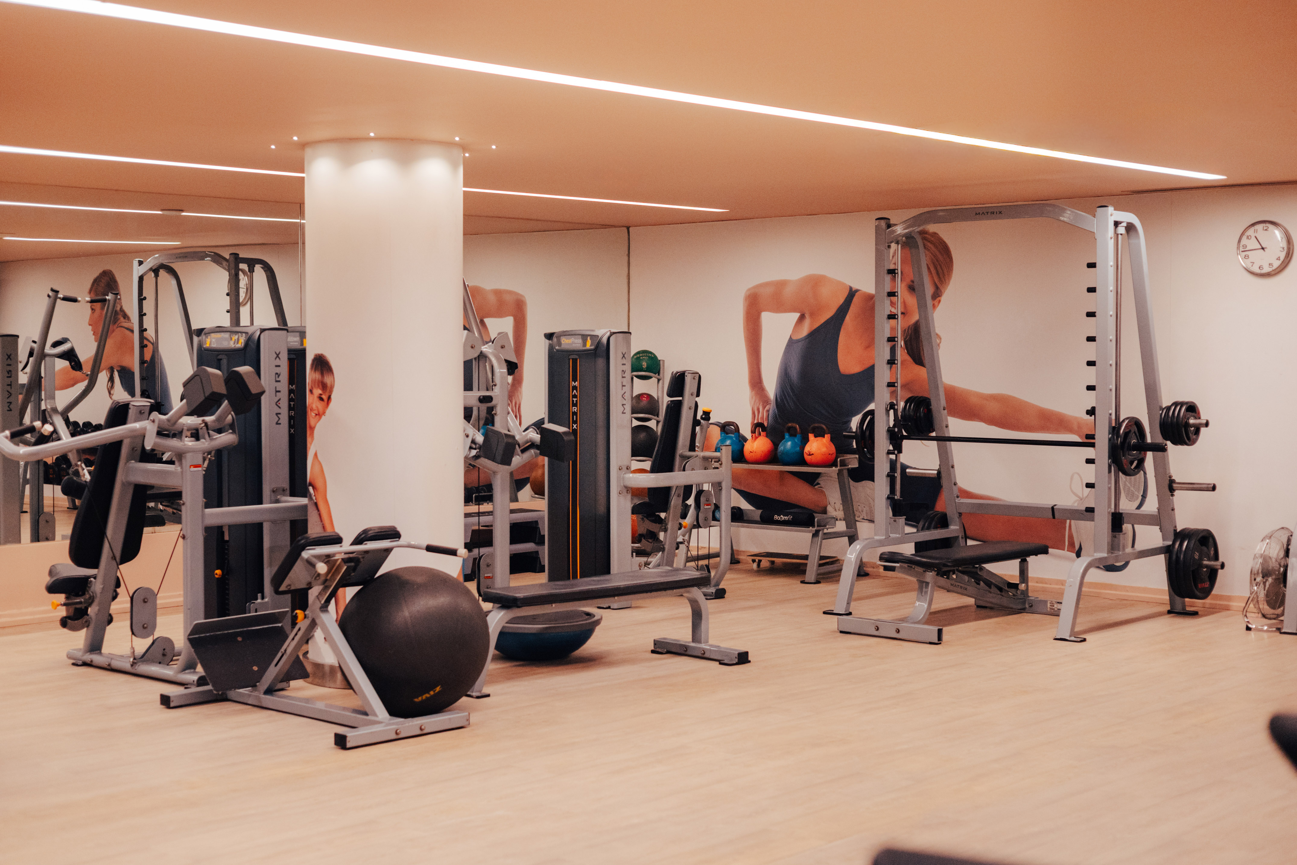 Spacious gym with Matrix fitness equipment, kettlebells, and weight machines.