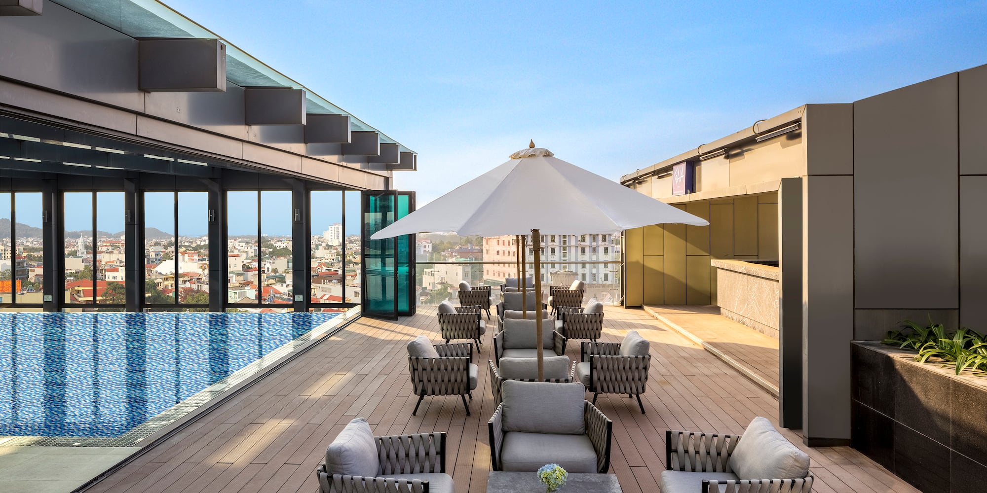 a patio with chairs and umbrellas on a rooftop