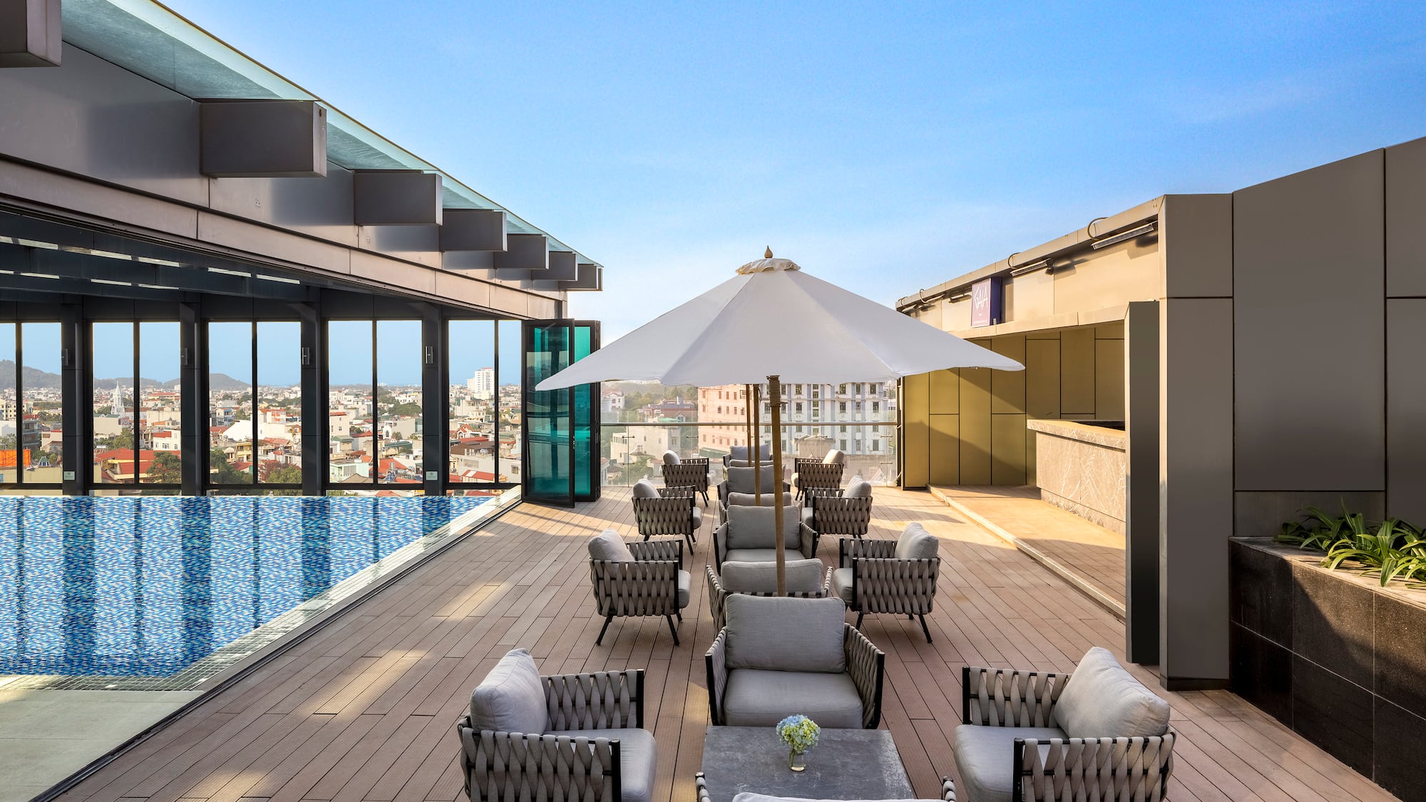 a patio with chairs and umbrellas on a rooftop