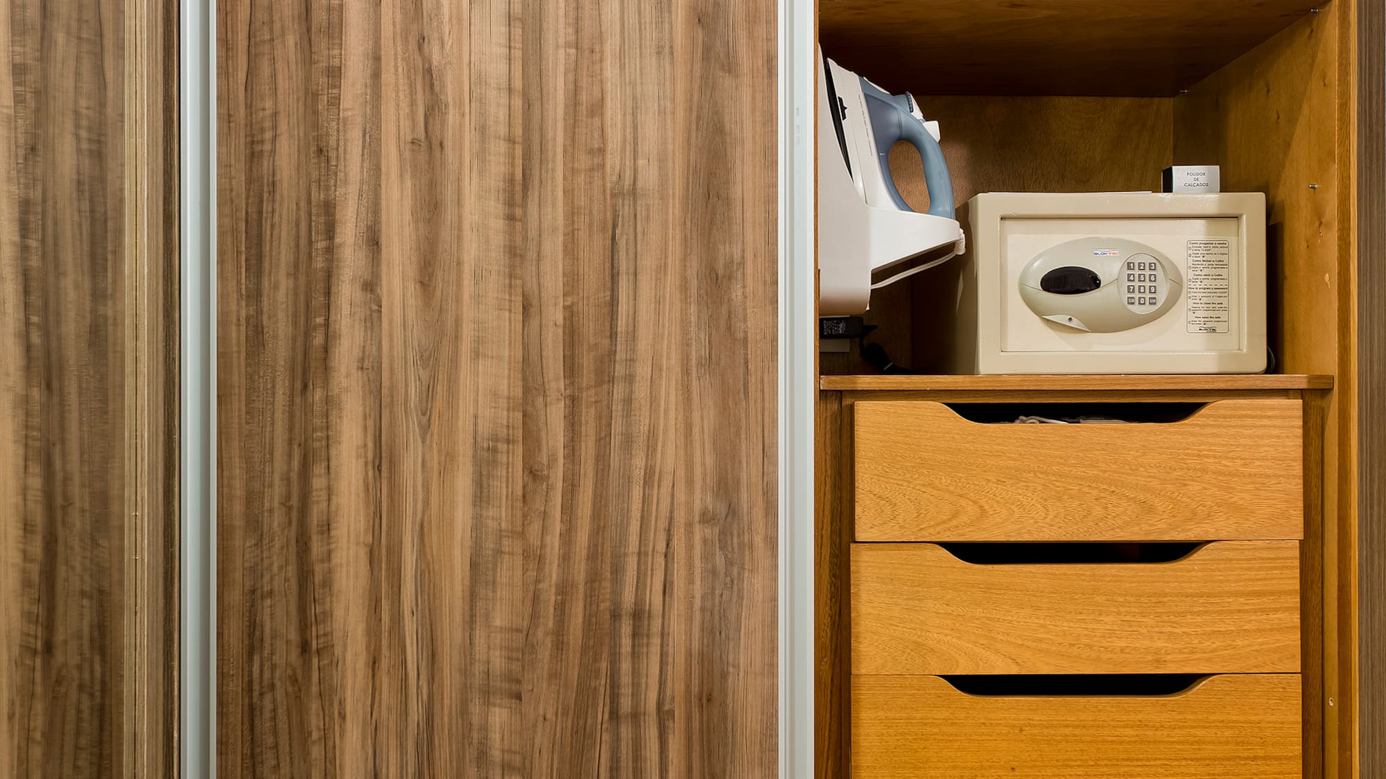 a closet with a microwave and a wood cabinet