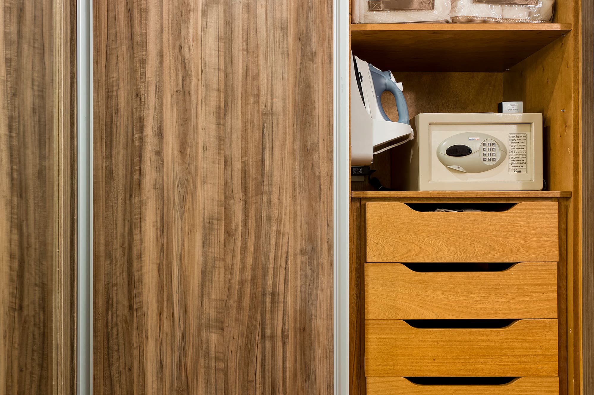 a closet with a microwave and a wood cabinet