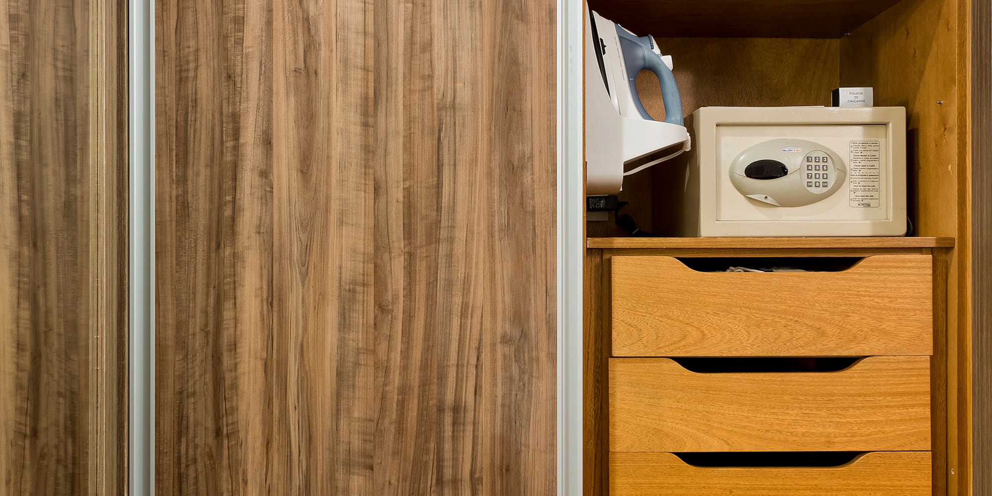 a closet with a microwave and a wood cabinet