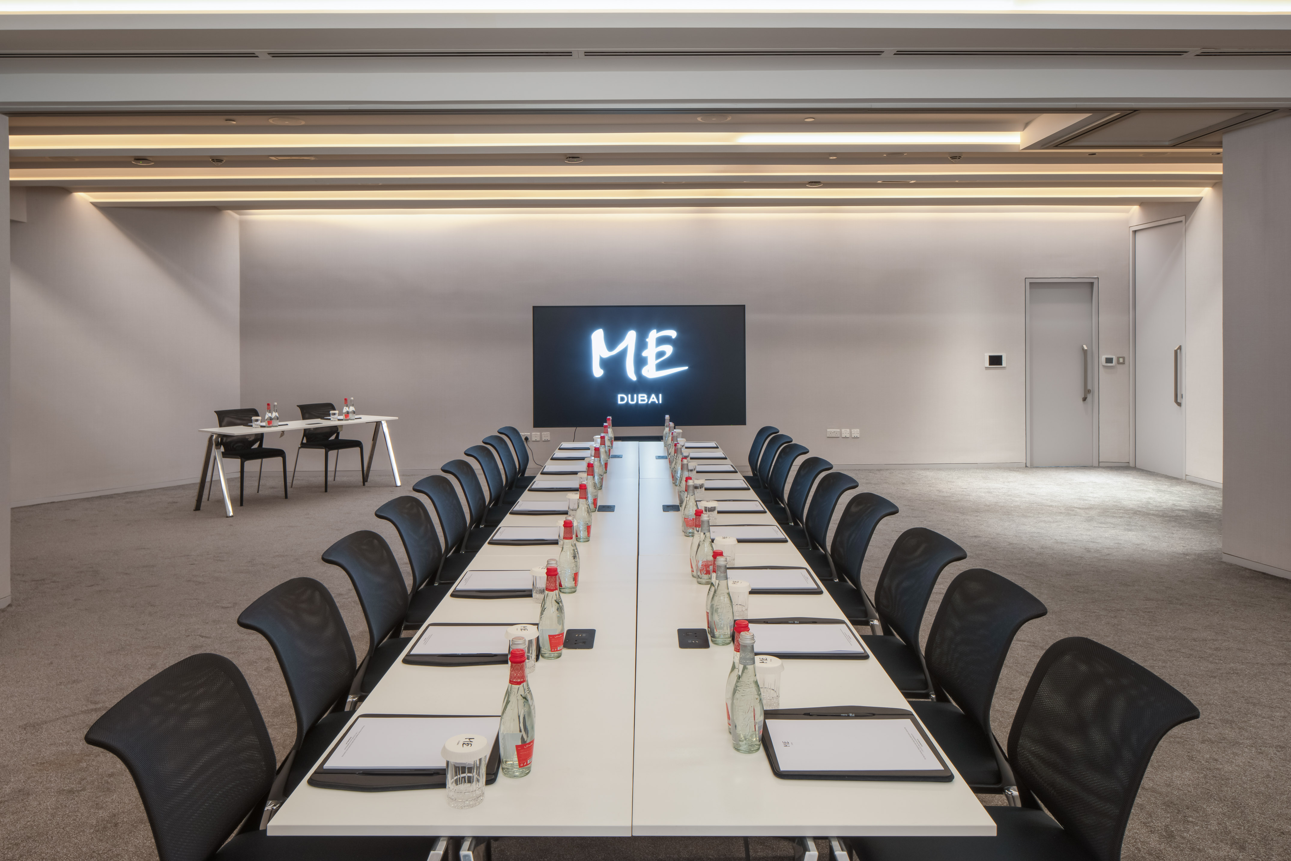 Sleek modern conference room in Dubai with long table and 'ME' screen.