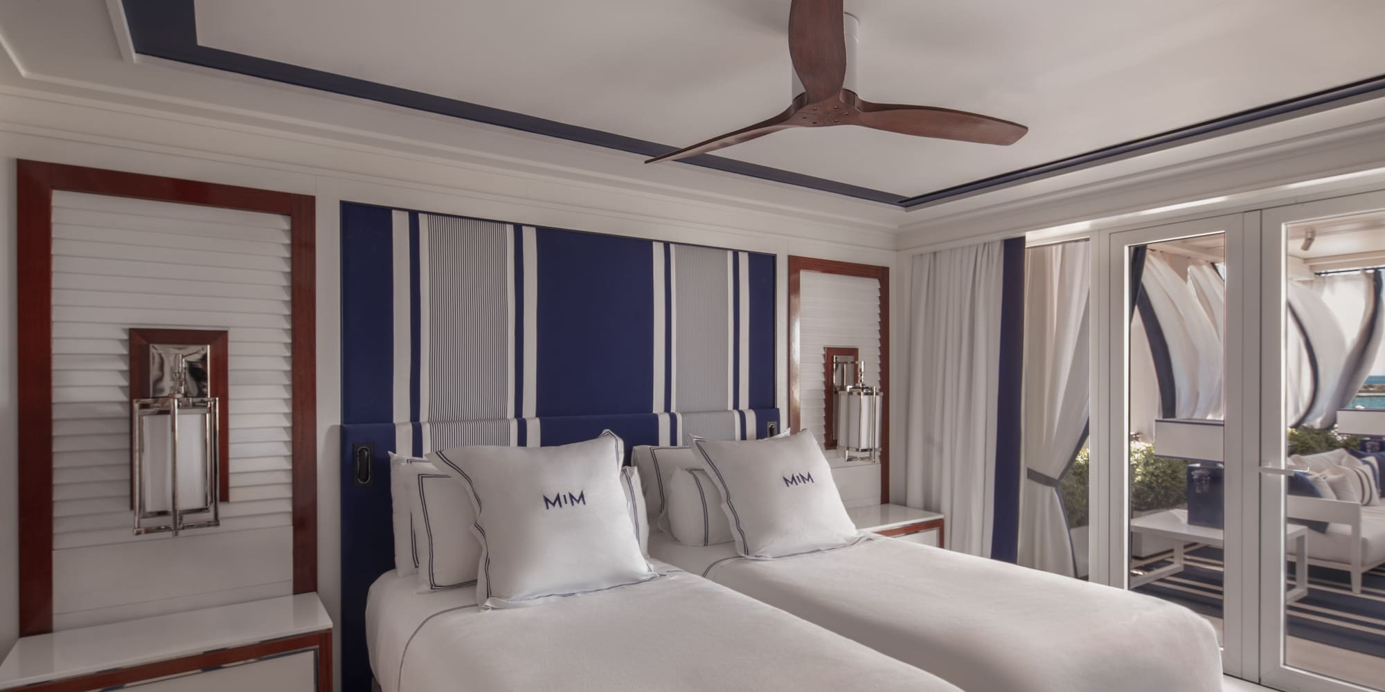 a room with two beds and a ceiling fan