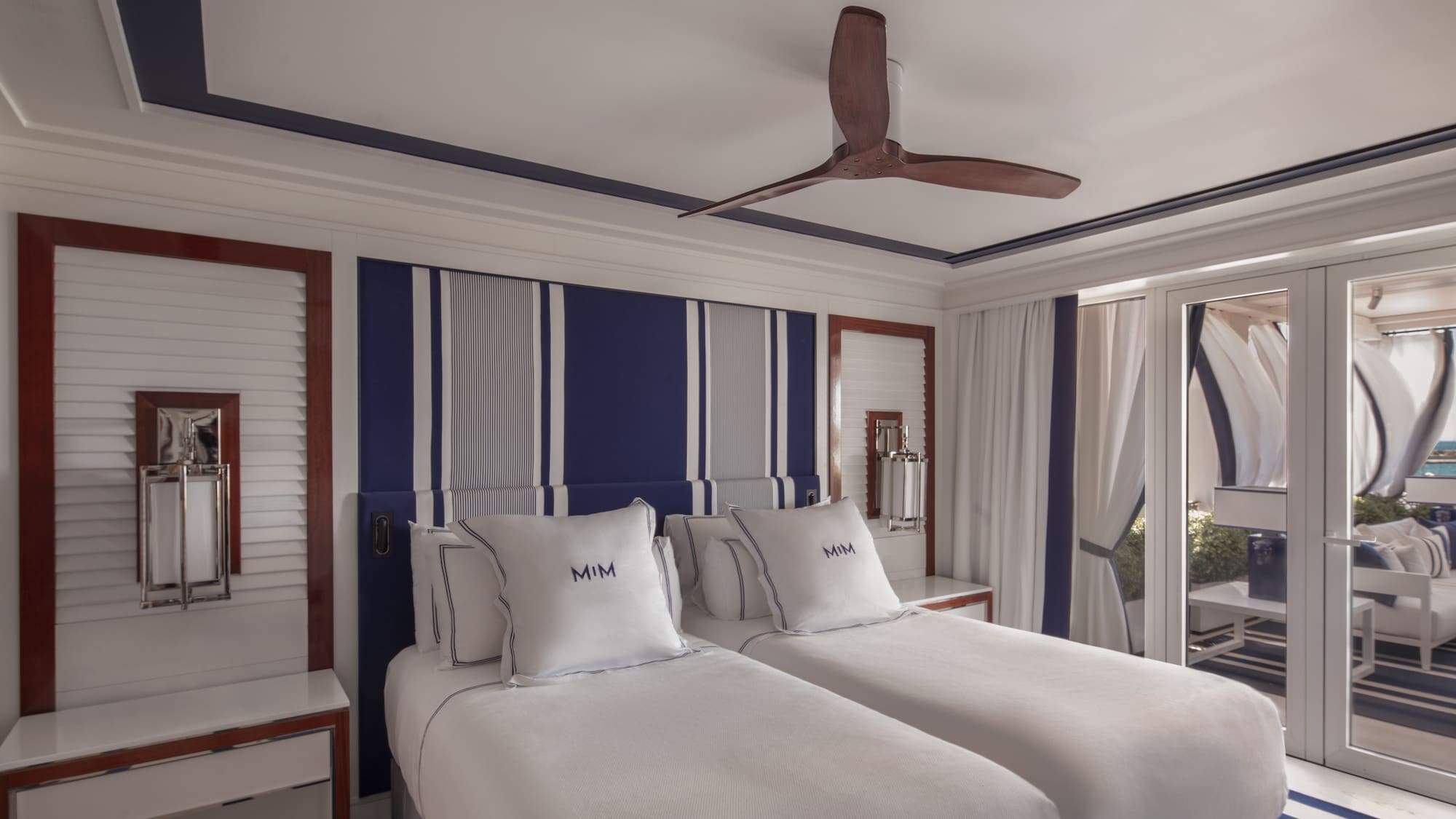 a room with two beds and a ceiling fan