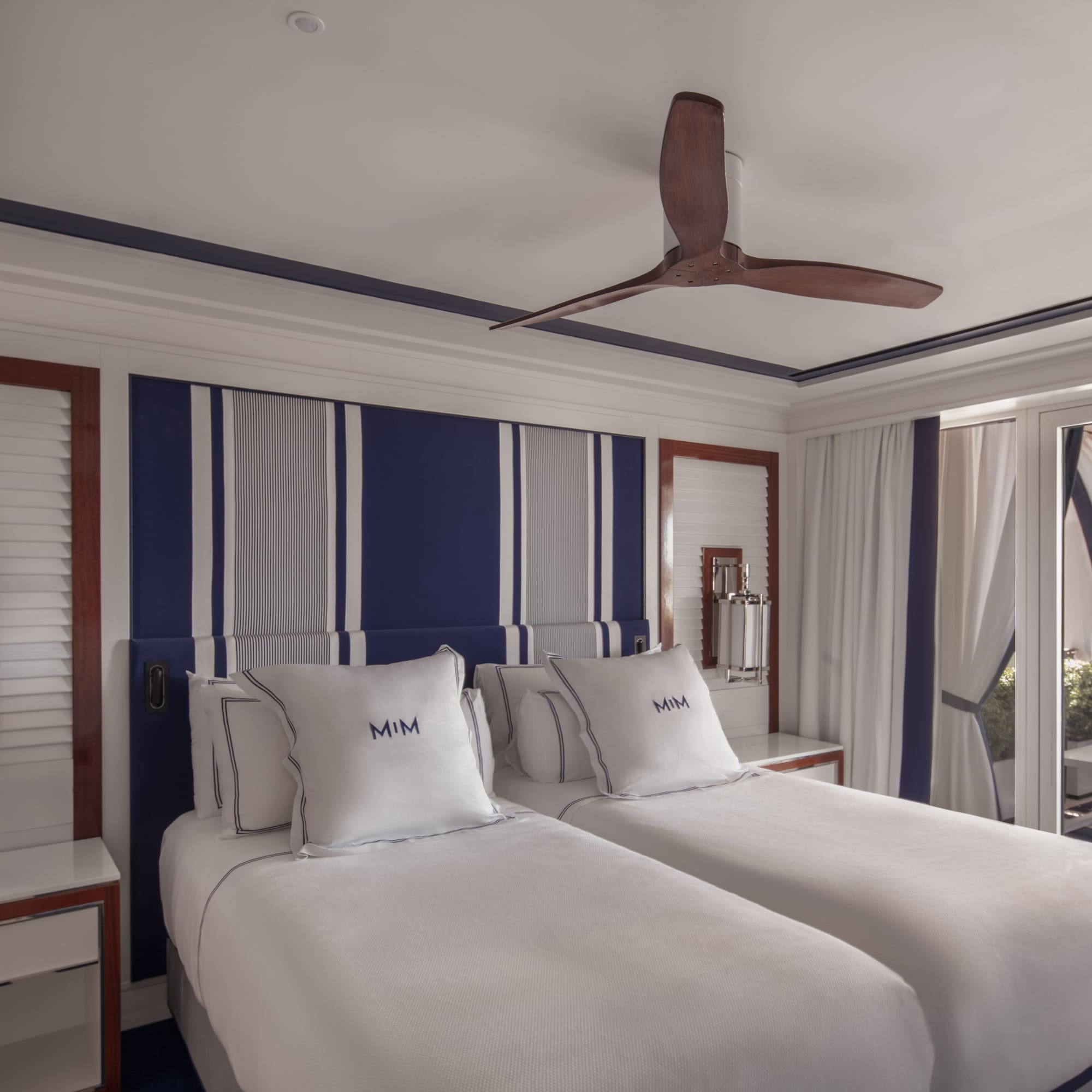 a room with two beds and a ceiling fan