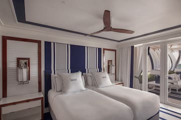 a room with two beds and a ceiling fan