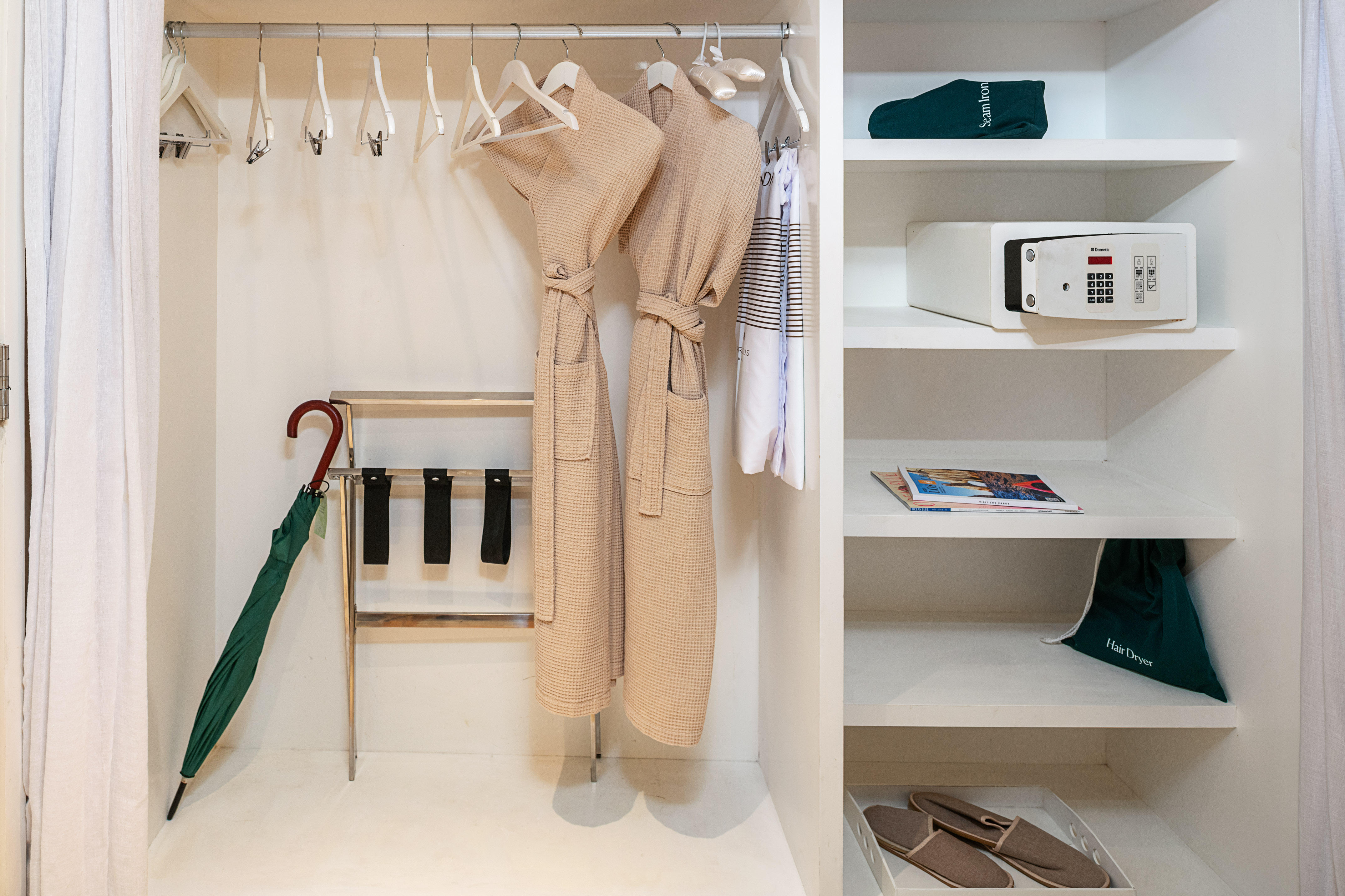 Hotel closet with bathrobes, safe, luggage rack, and guest amenities.