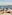 Family with two kids laughing on a boat, dad pointing to the ocean.