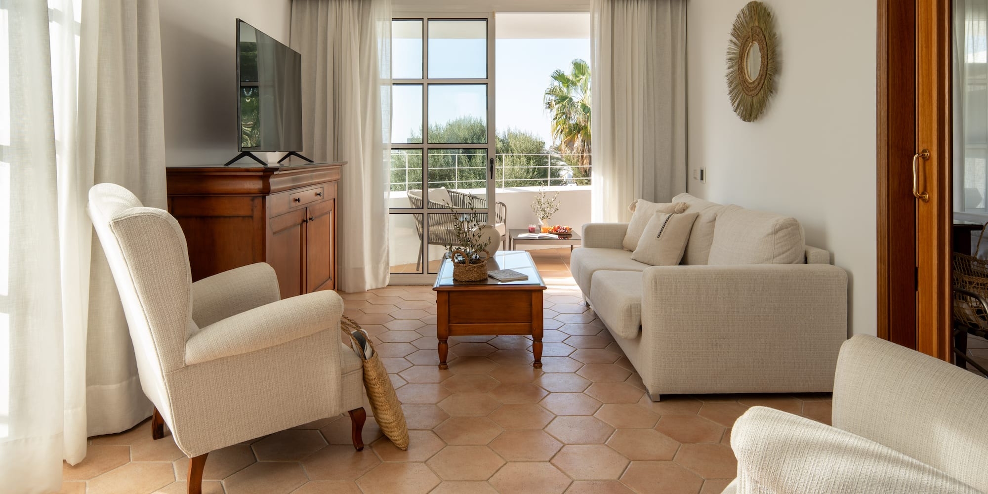a living room with white furniture and a television