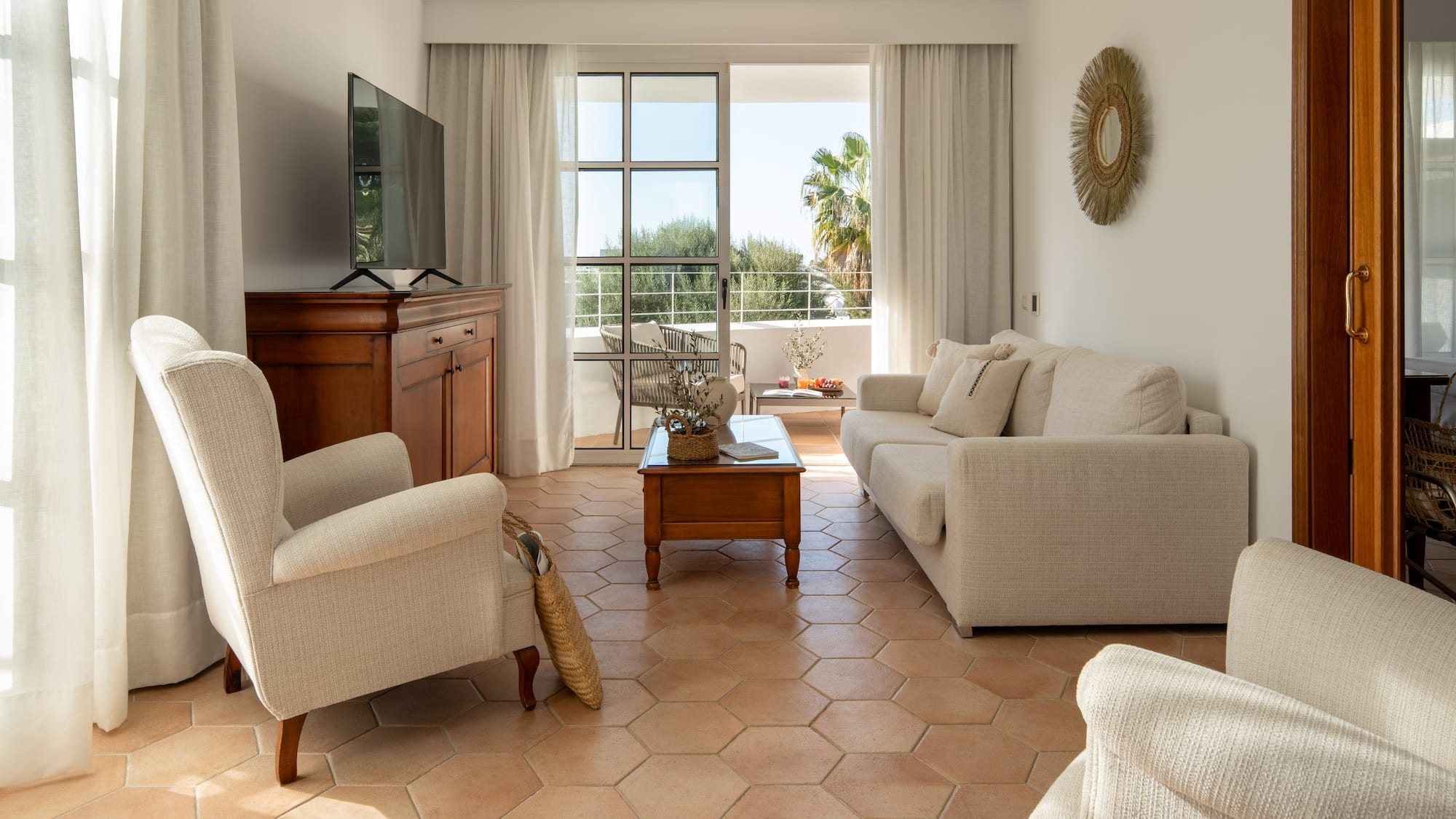 a living room with white furniture and a television
