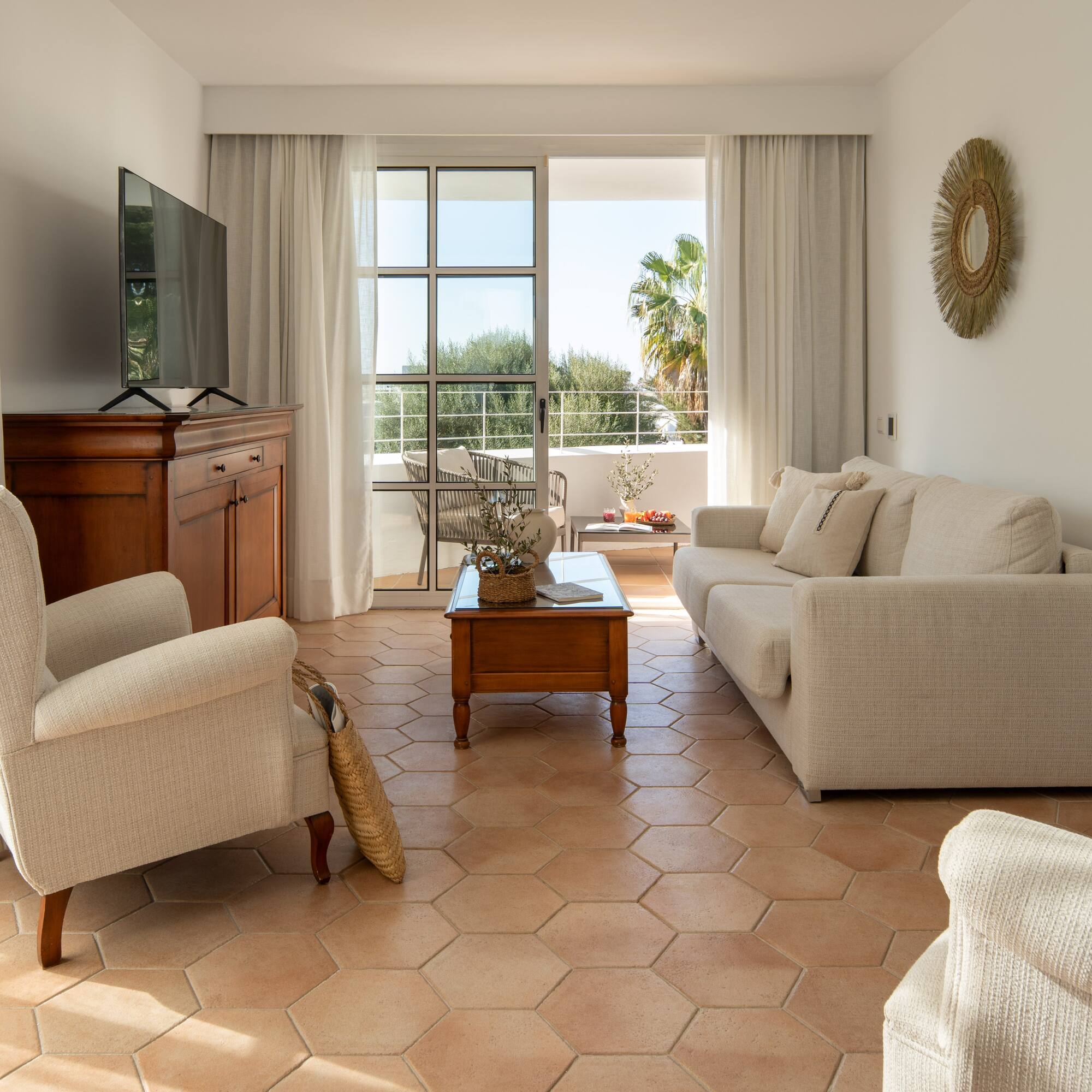 a living room with white furniture and a television