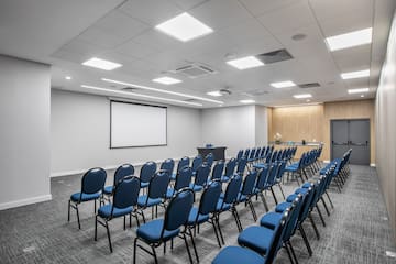 a room with rows of blue chairs