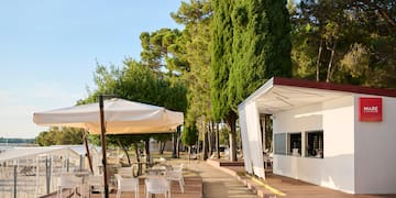 a white building with tables and umbrellas