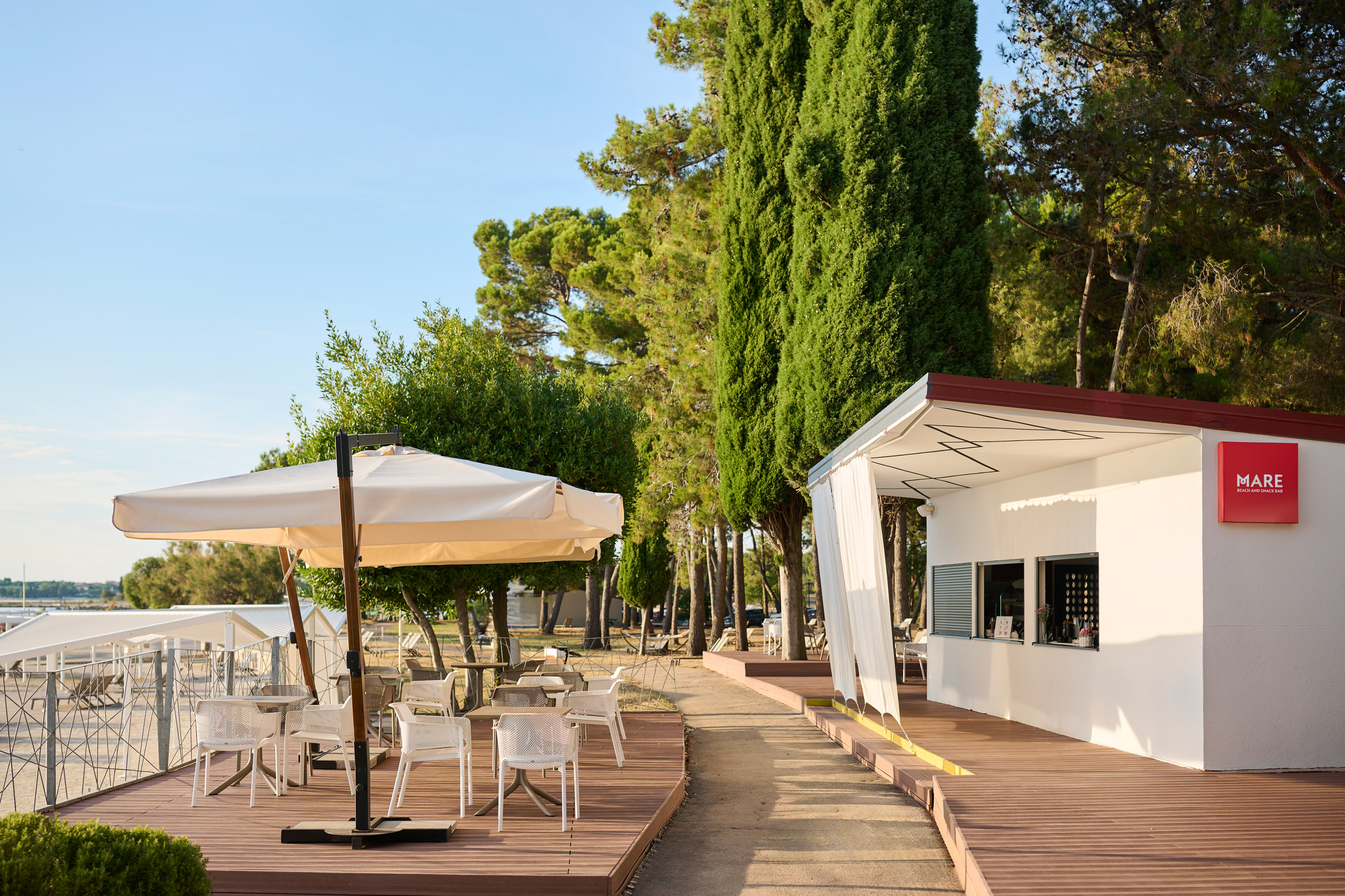 a white building with tables and umbrellas