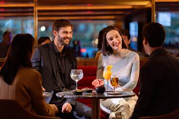 a man and woman sitting at a table with drinks