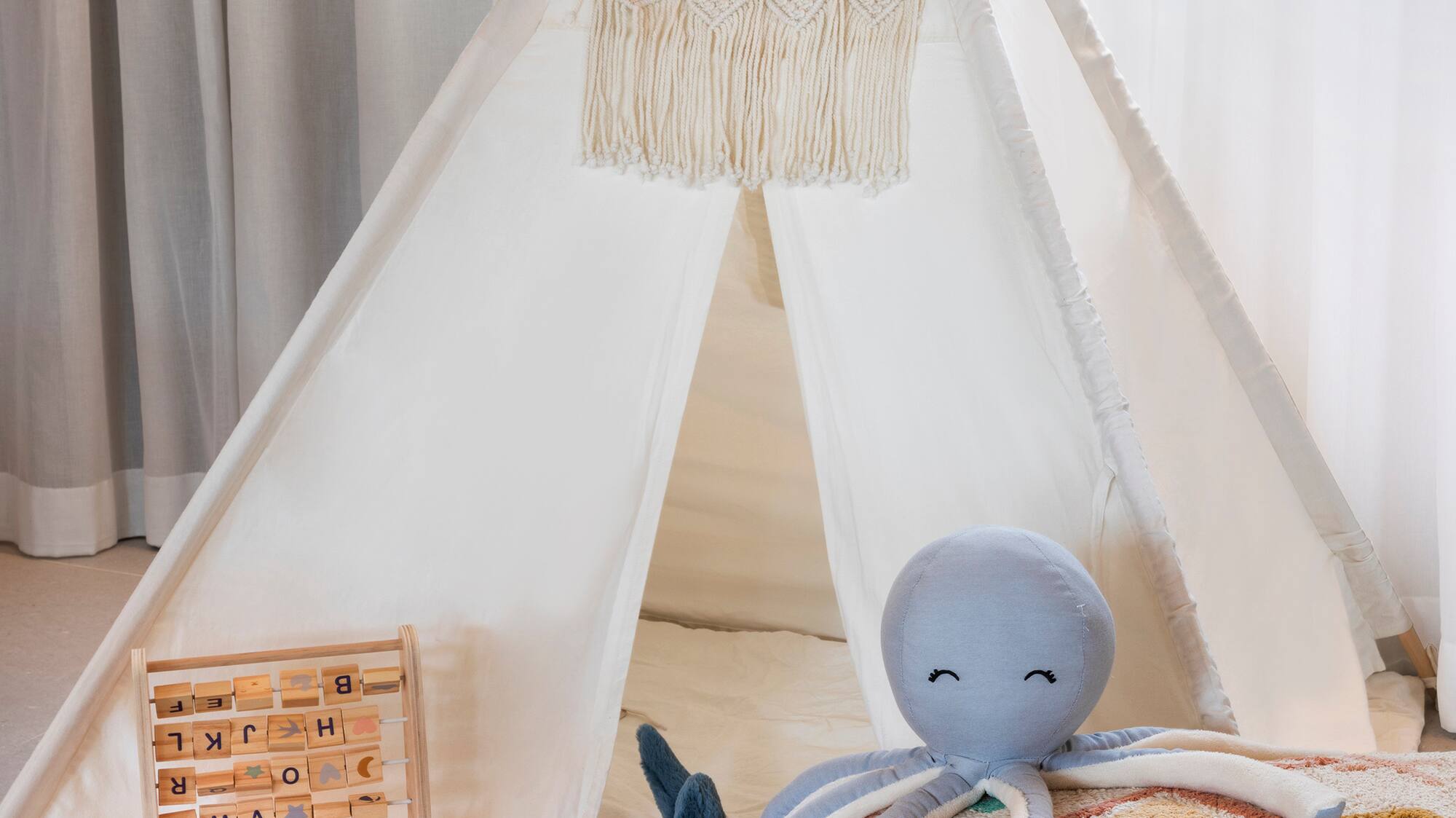 a teepee with toys and a stuffed animal