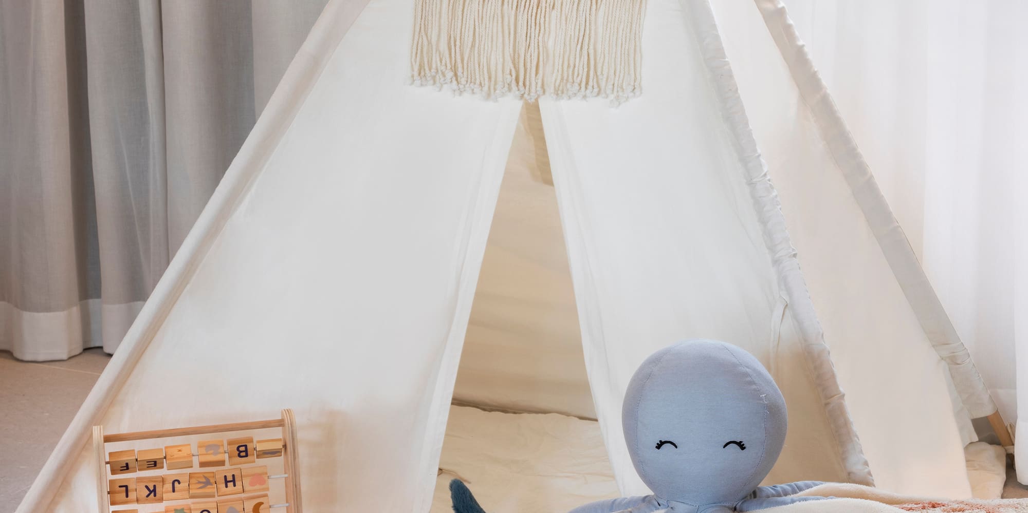 a teepee with toys and a stuffed animal