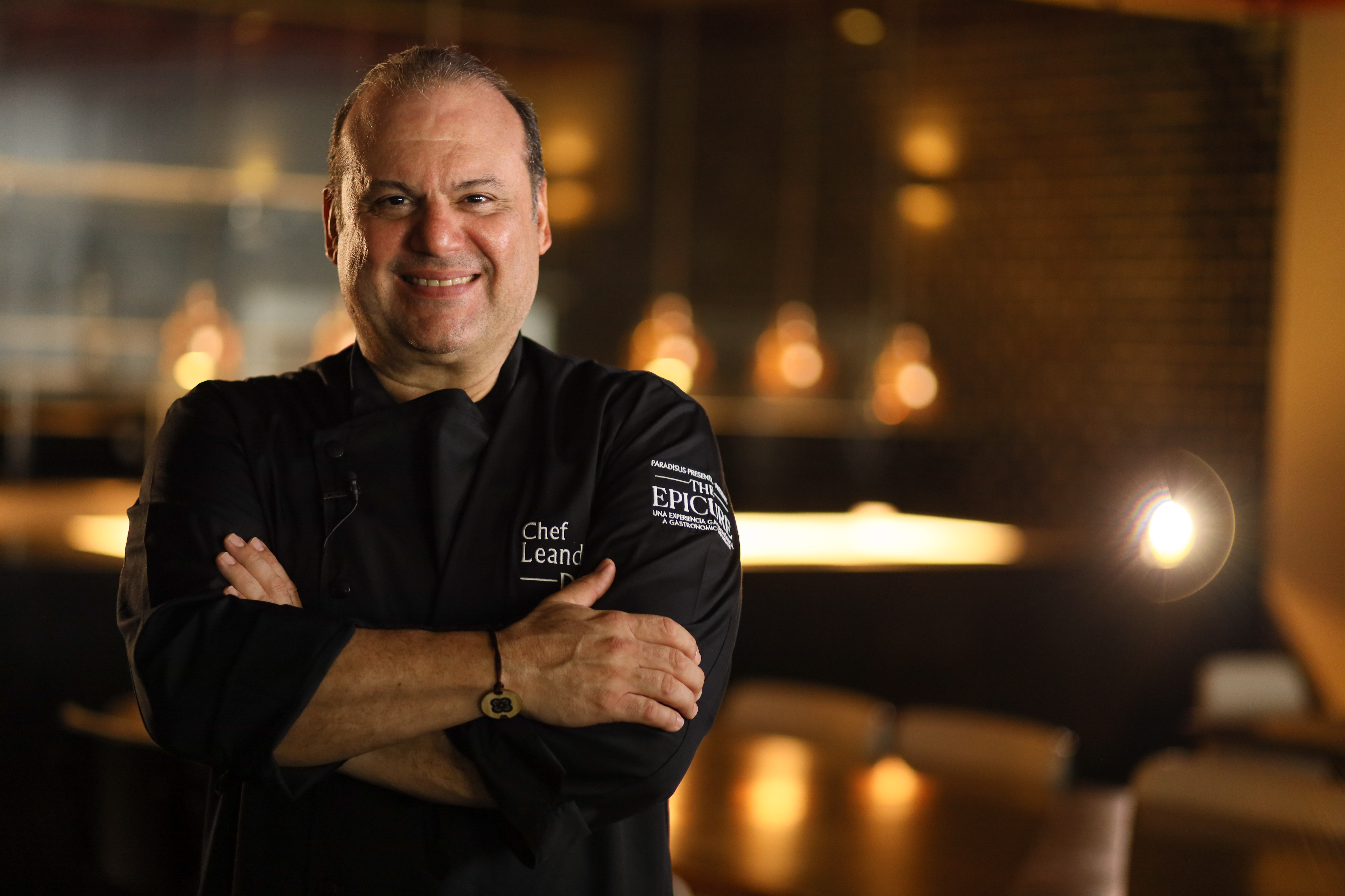 Chef Leandro smiling in black chef uniform for an Epicure event.