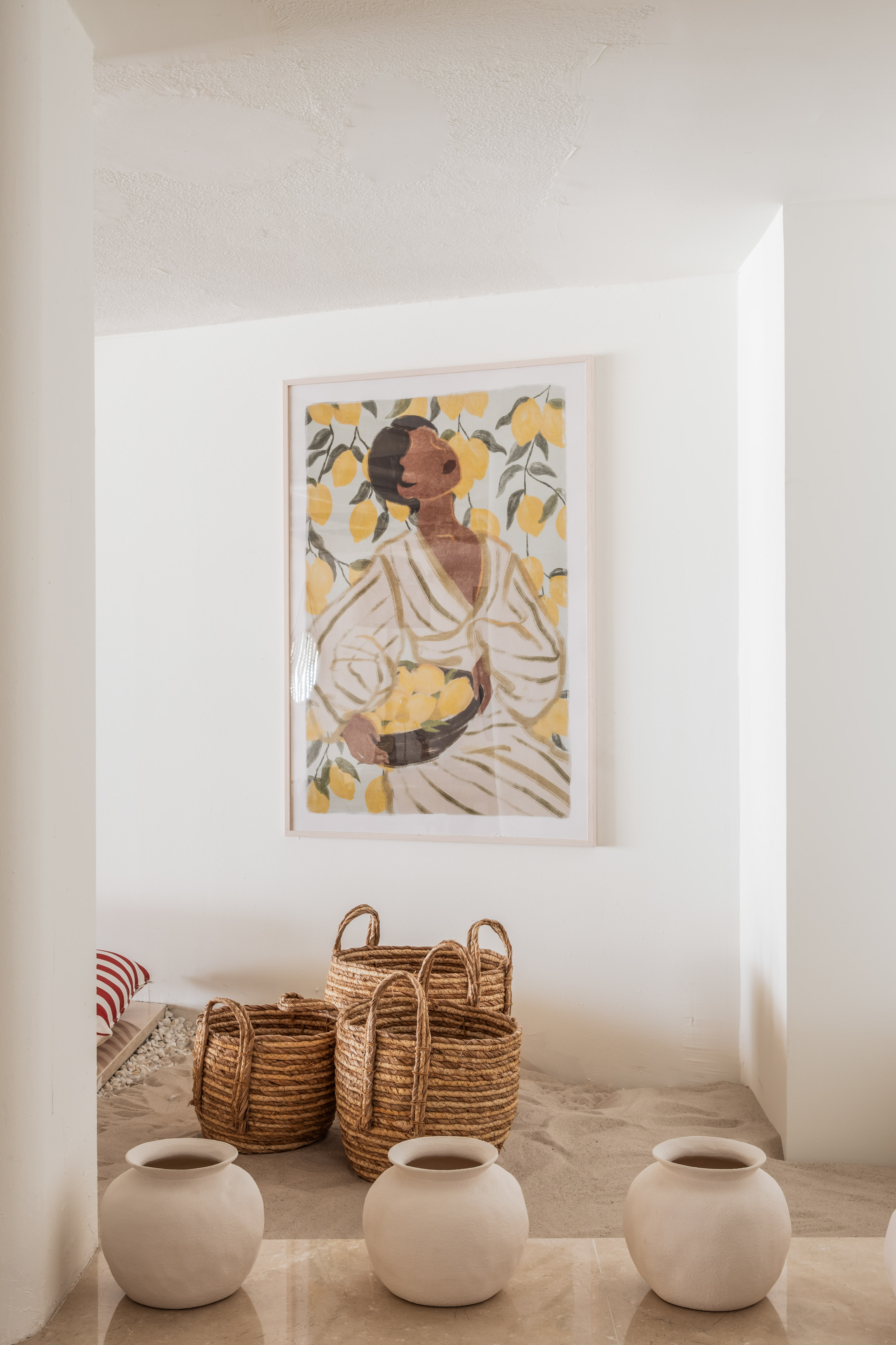 Bohemian decor with lemon wall art, natural woven baskets, white ceramic pots.
