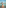 Woman in black swimsuit kneeling on wet beach sand by turquoise water.