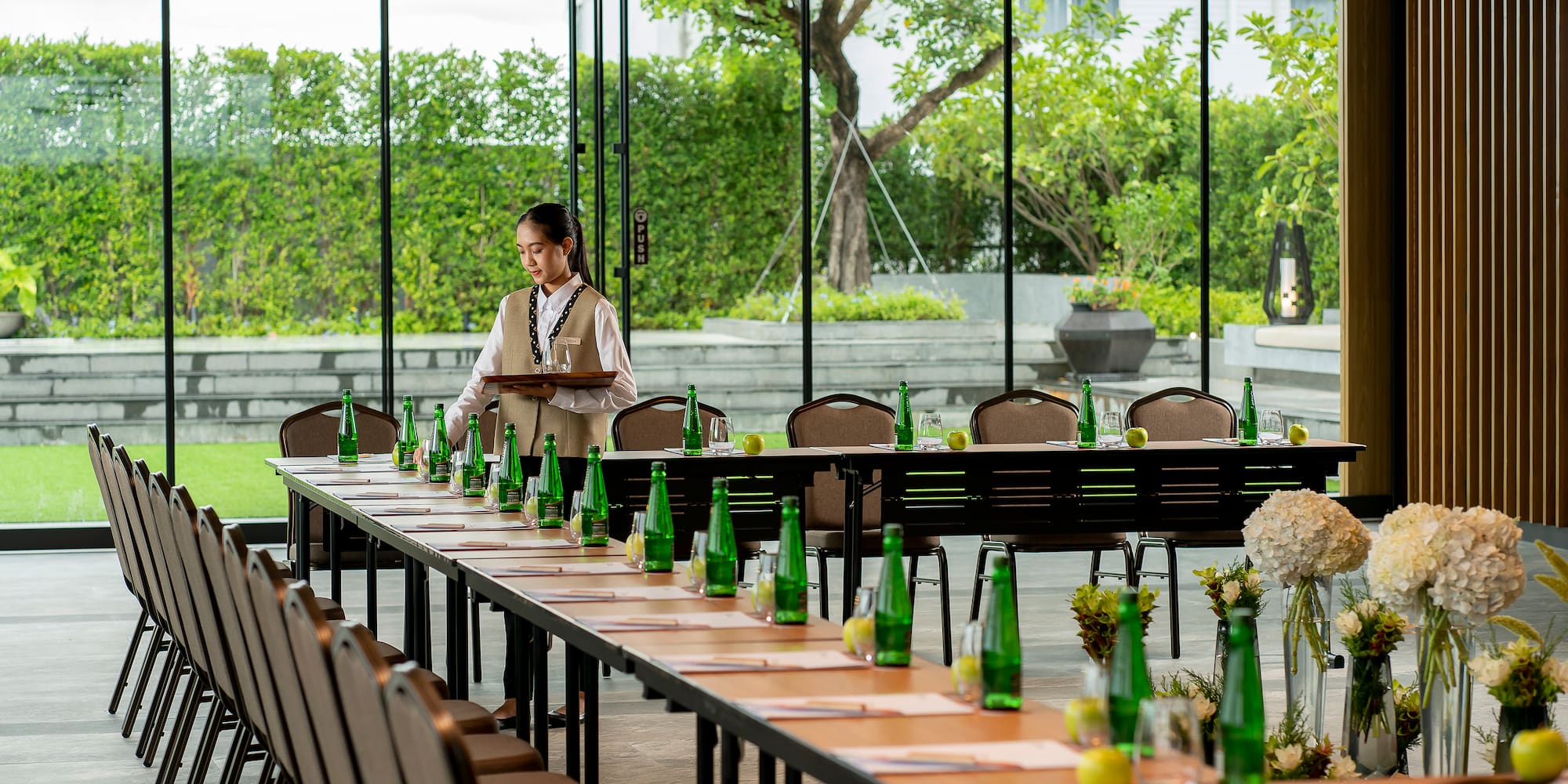 a woman standing at a table with empty bottles