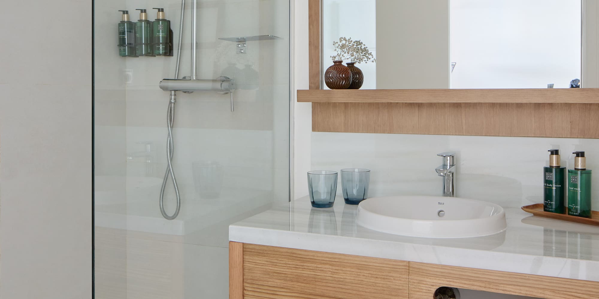 a bathroom with a glass shower and sink