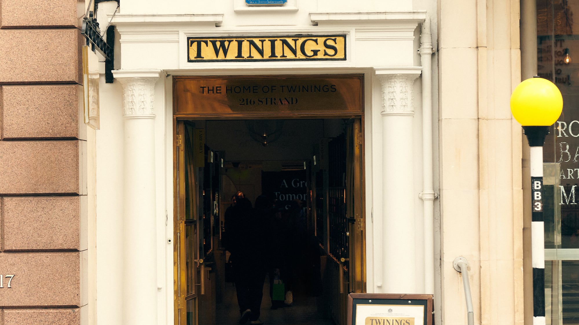 a building with a sign and a couple of statues on top of it