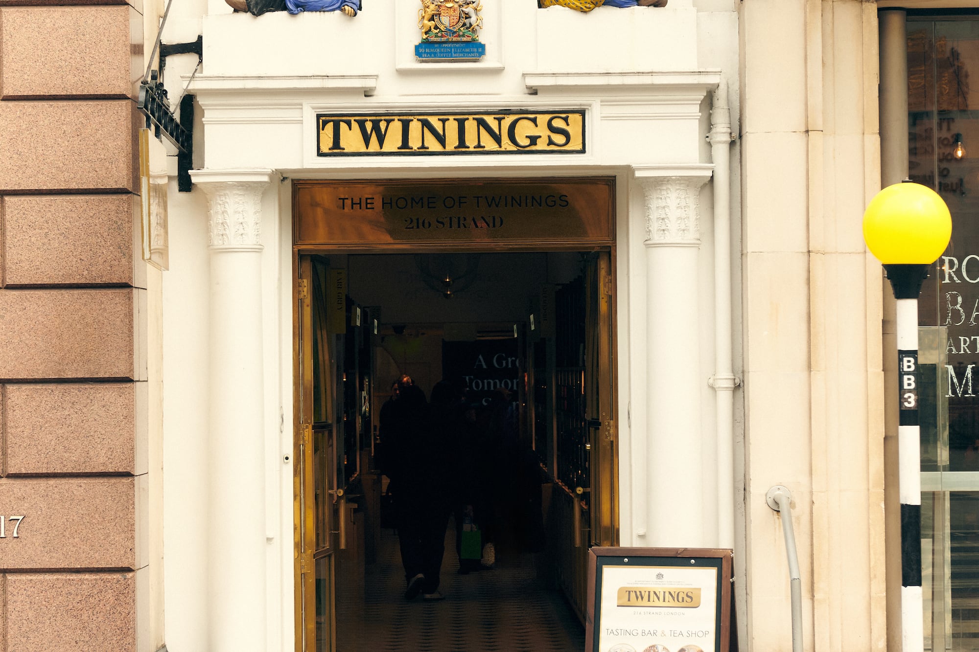 a building with a sign and a couple of statues on top of it