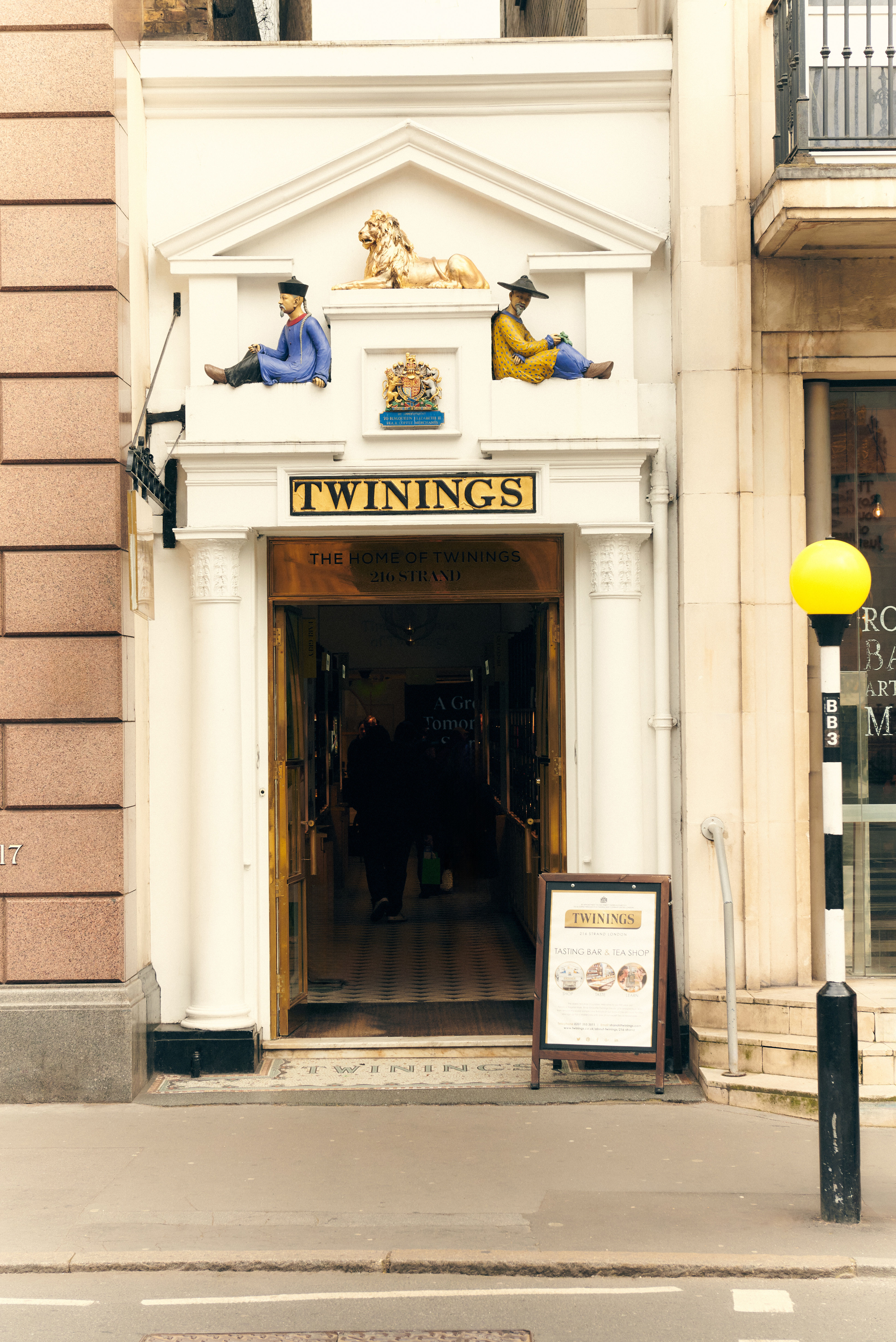 a building with a sign and a couple of statues on top of it