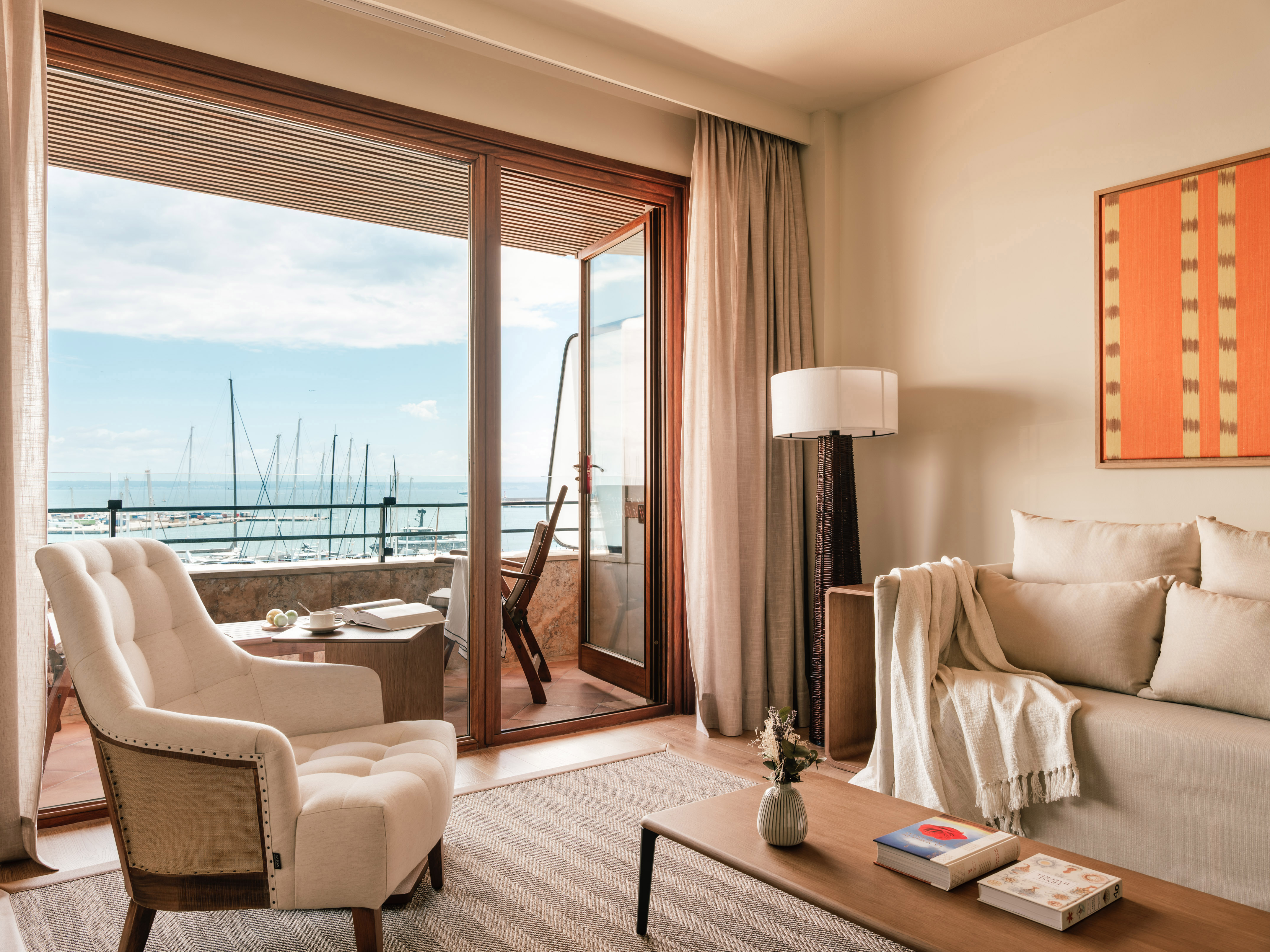 Coastal living room with balcony overlooking marina and sea view.