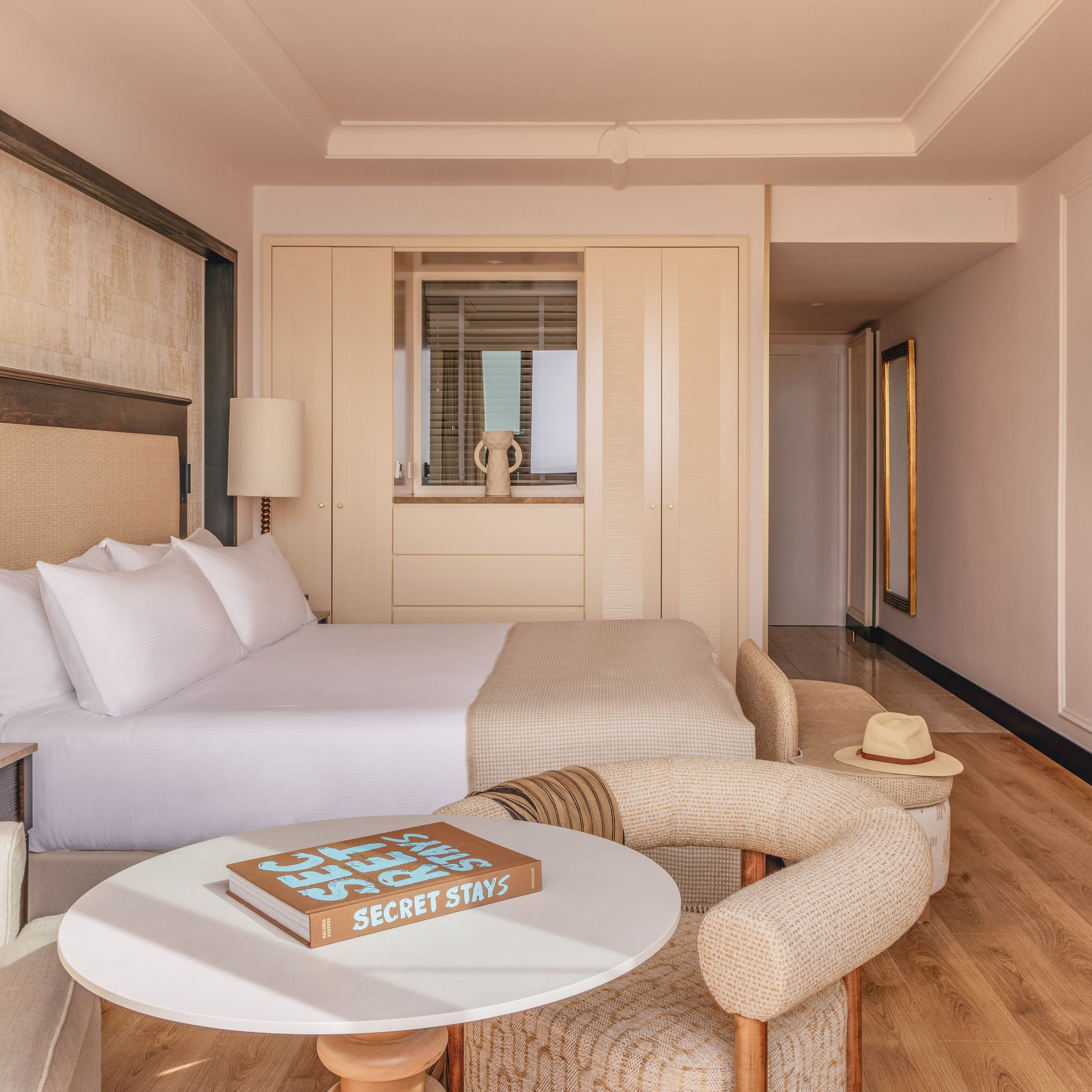 a bed with a headboard and a table with lamps