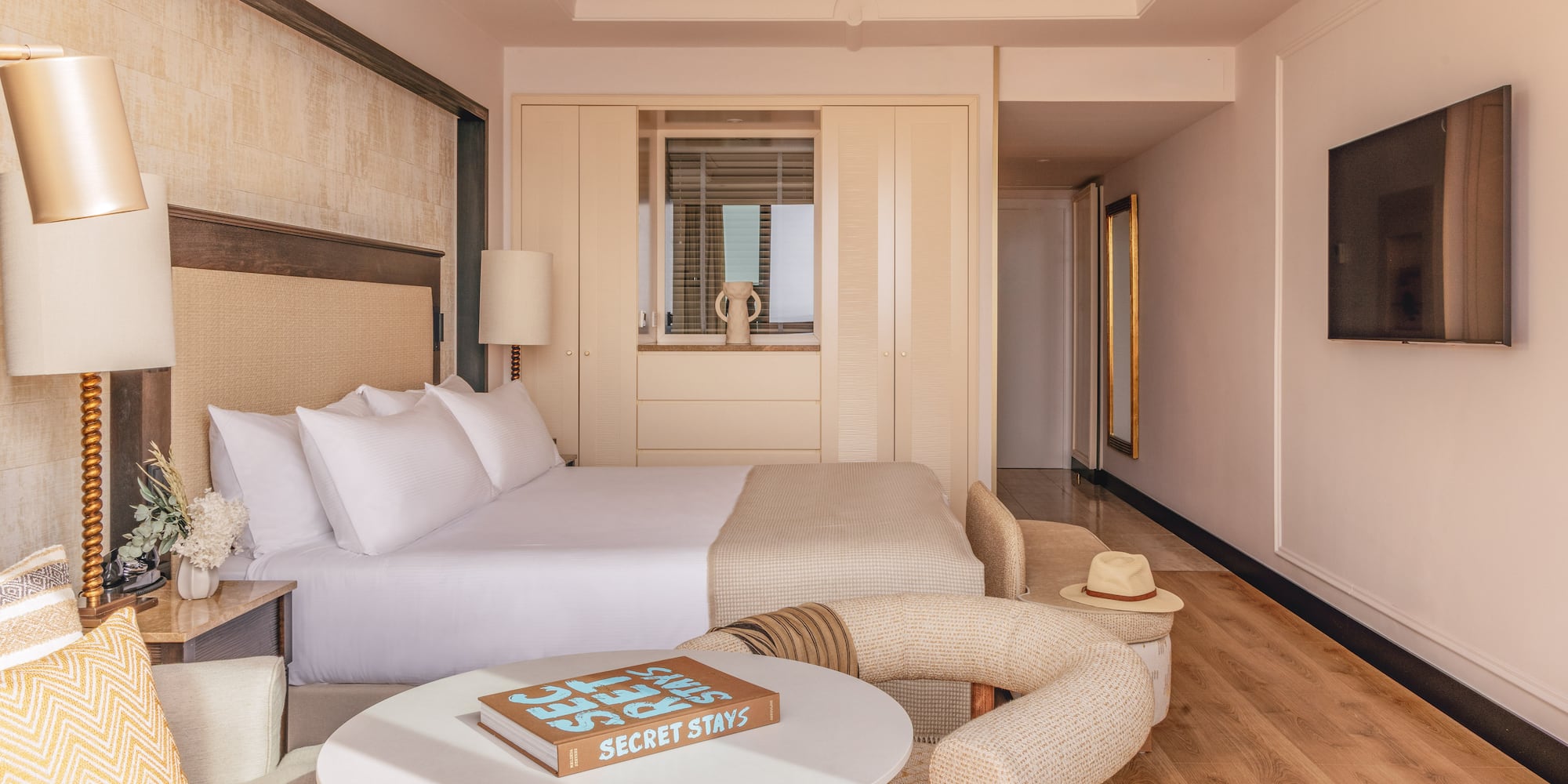 a bed with a headboard and a table with lamps